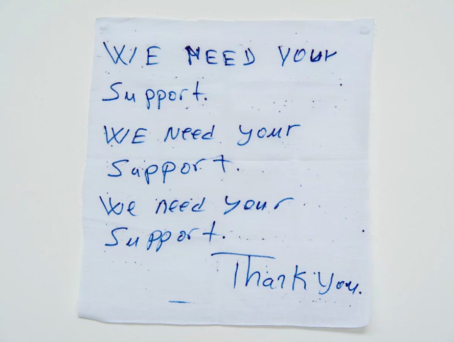 ‘We need your support’: a hand written note from a detainee on Manus Island . Photograph: David T Young/ Penny Ryan