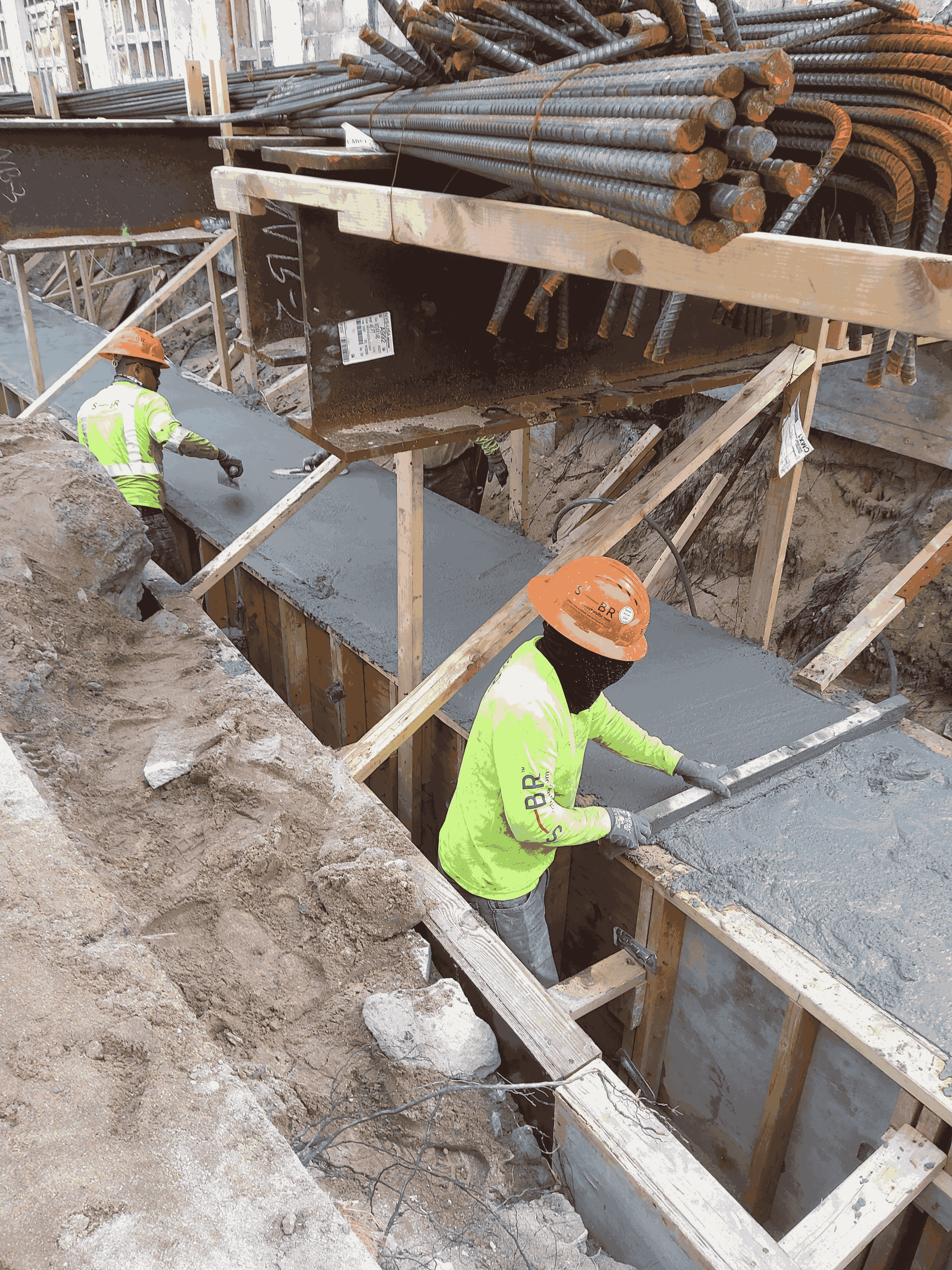 Trenches dug by hand on the west and east sides of the building, then filled with post-tensioned concrete to support the moving mechanism.