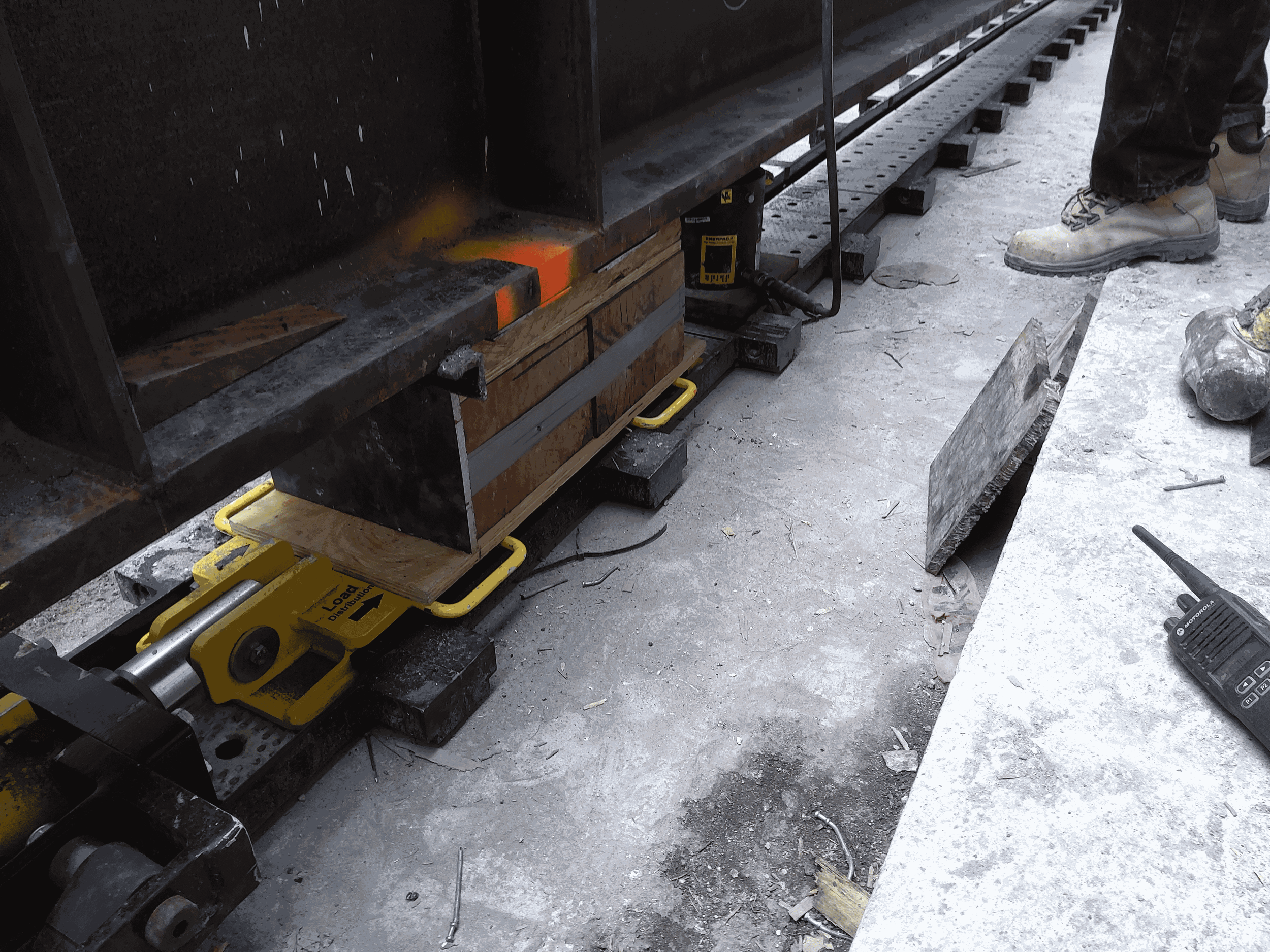 Close-up of the jacking beam resting on a mechanism made up of woodblocks, skid beams, and a unidirectional track.