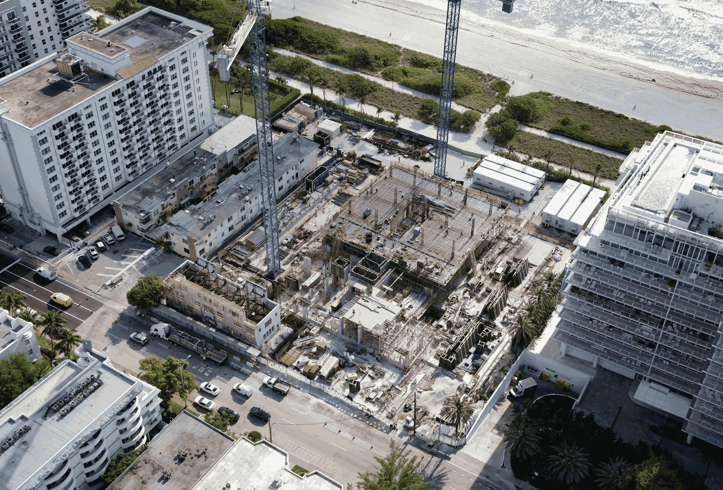 Aerial view of the jobsite, showcasing the preservation and strengthening of the historic building's façade alongside the construction of the new adjacent development.