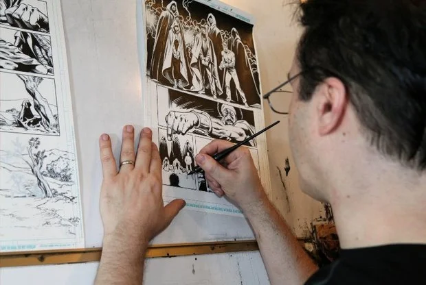 Scott Hanna inks a comic book panel at his home studio in Riegelsville. (LehighValleyLive.com Photo)