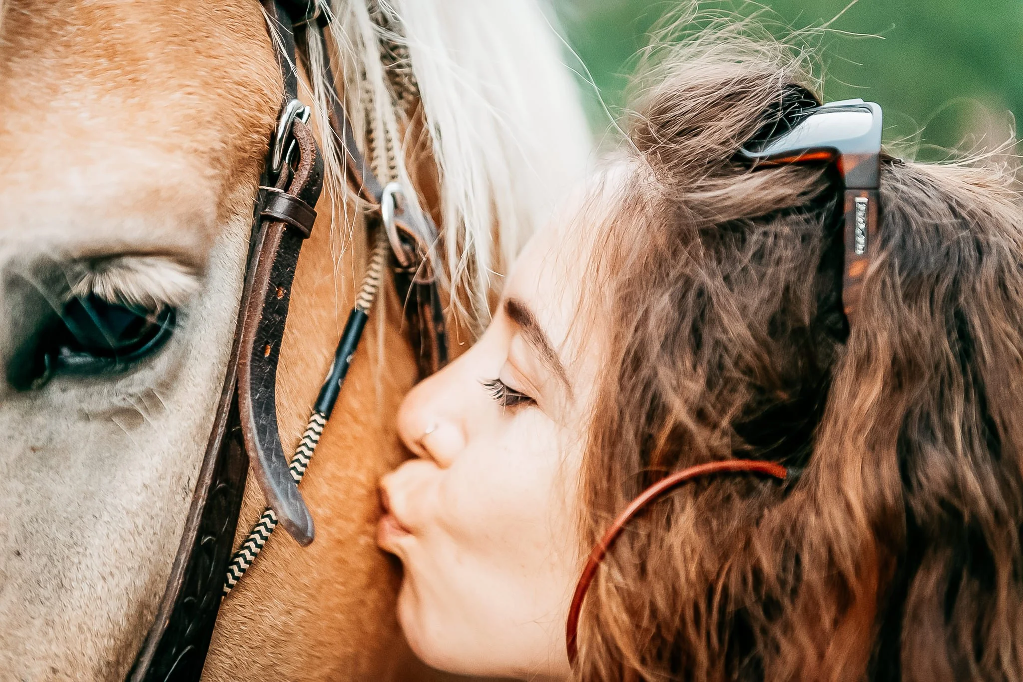 Portrait of woman trail riding her horse in the mountains during the summer. 
