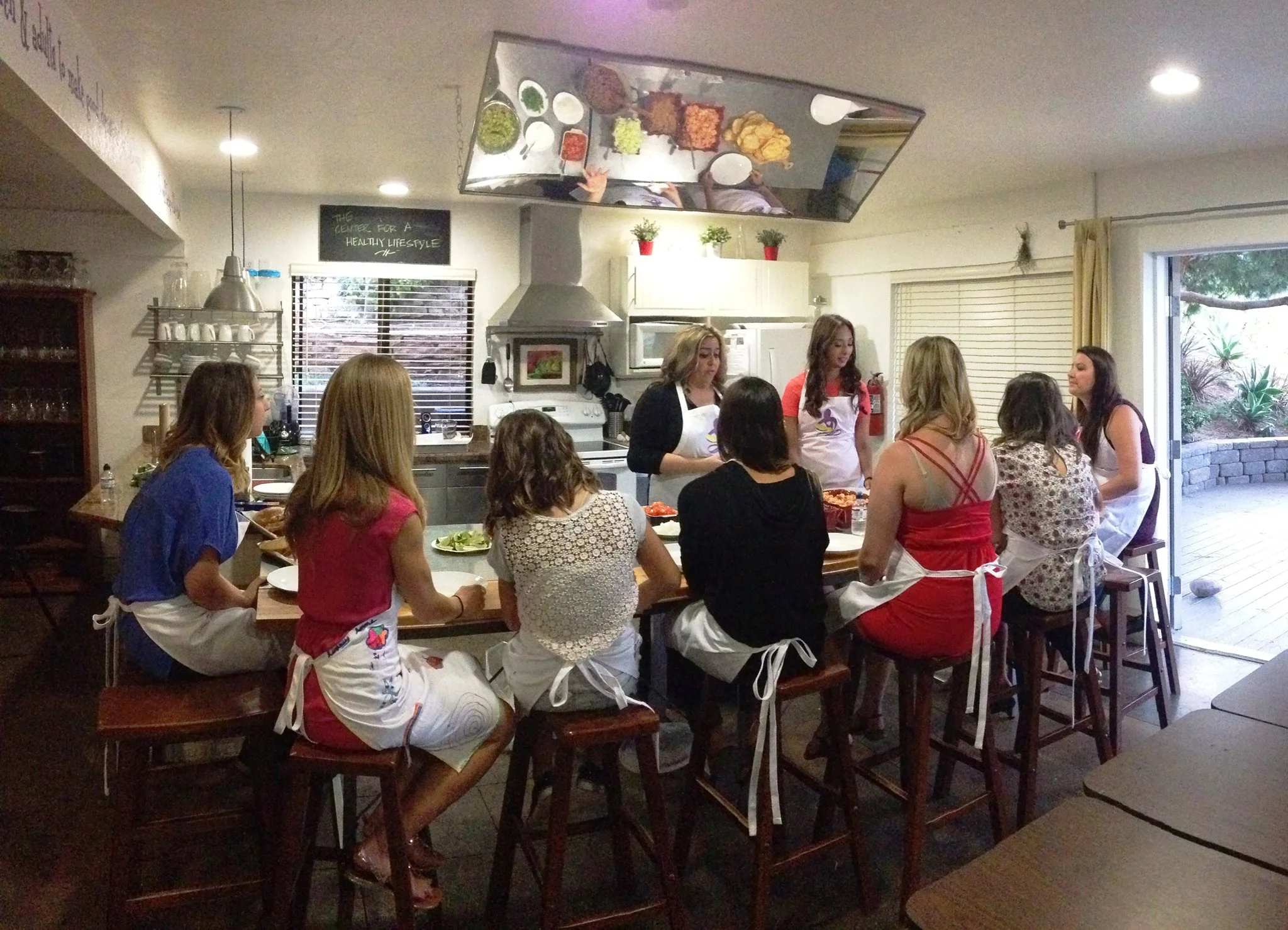 Chula's Mission founders Mayra San Juan and Lyndsey Ruiz work with mentees in the kitchen.