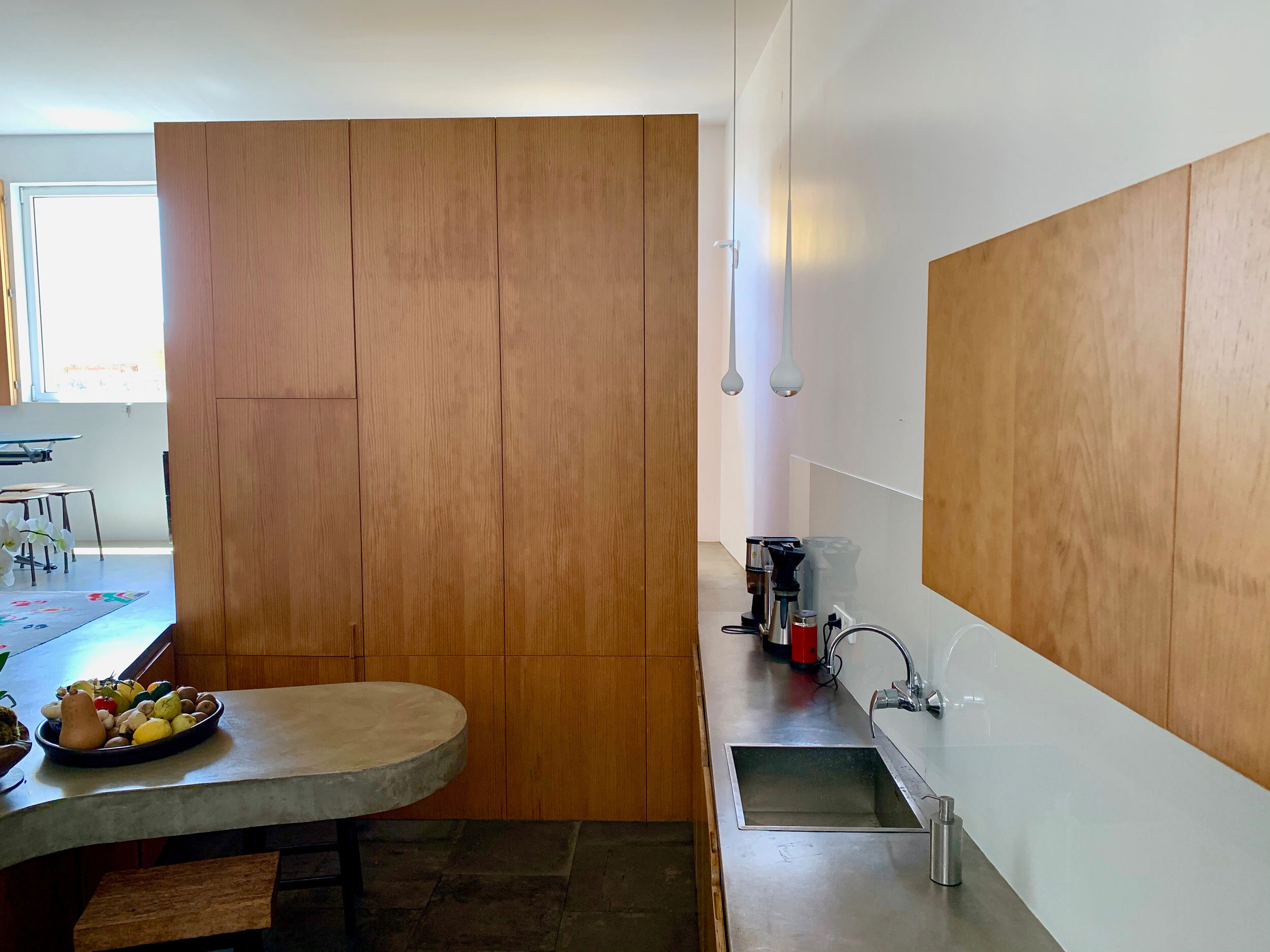 The wooden screen area contains the refrigerator and storage