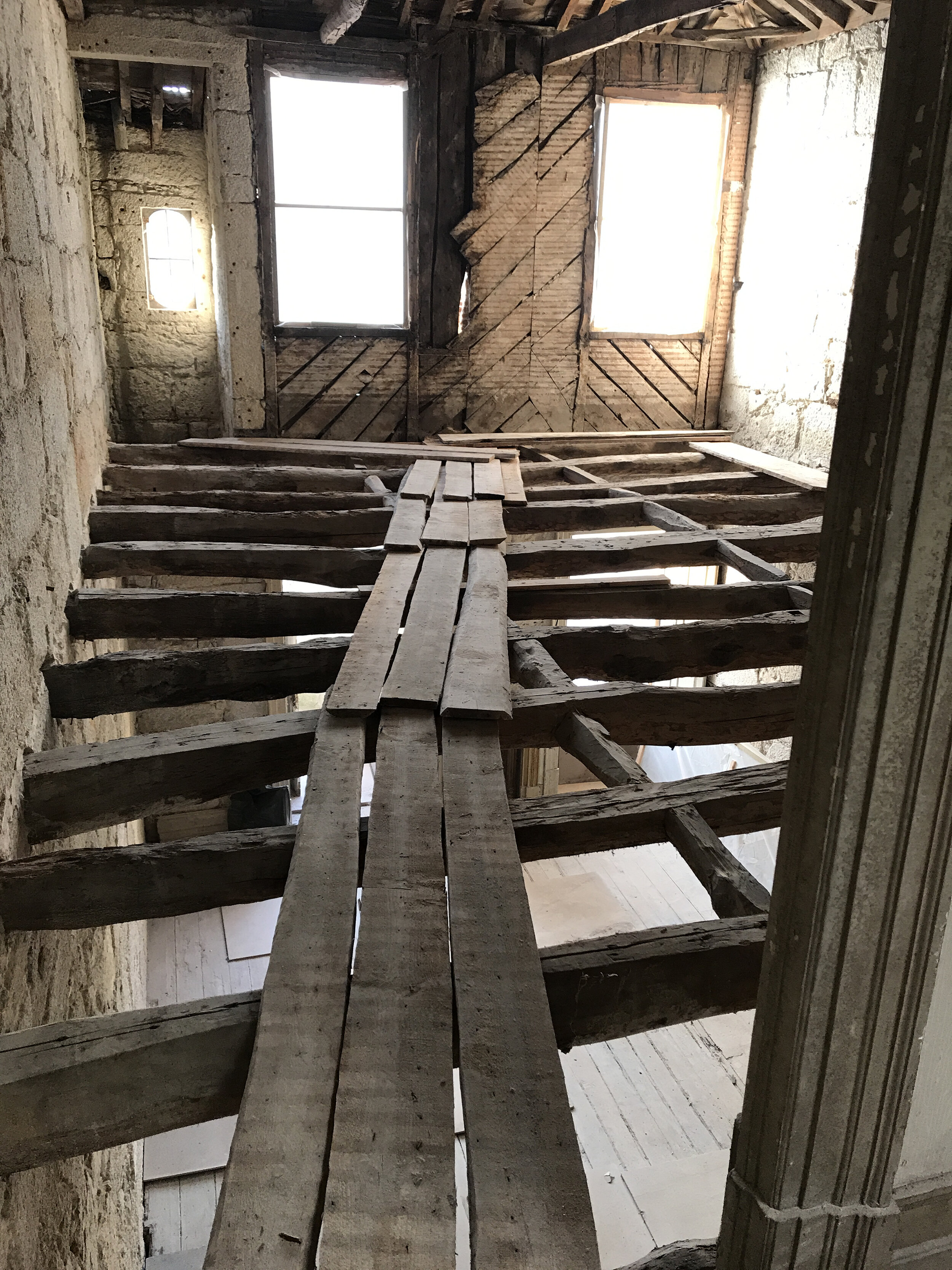 Looking through the floor joists at the beginning of construction in apartment E