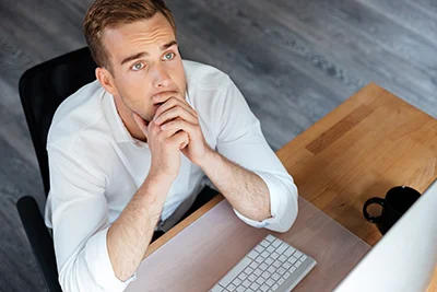 graphicstock-top-view-of-pensive-young-businessman-working-with-computer-and-thinking-at-workplace_BuxepozSnx.jpg