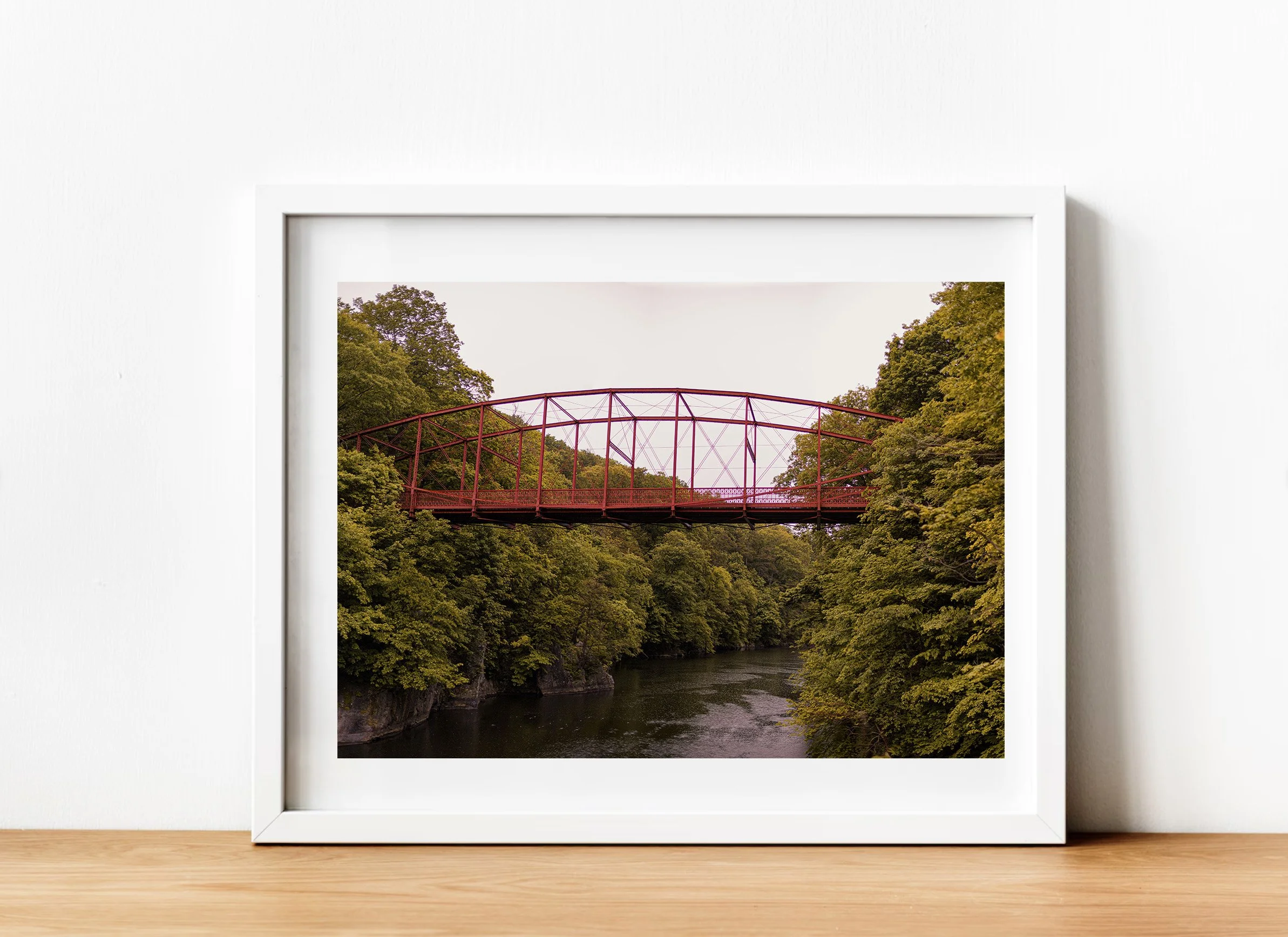 Historic red iron bridge at Lovers Leap State Park in Connecticut crossing above the Housatonic River with green trees and scenic forest landscape surrounding the gorge