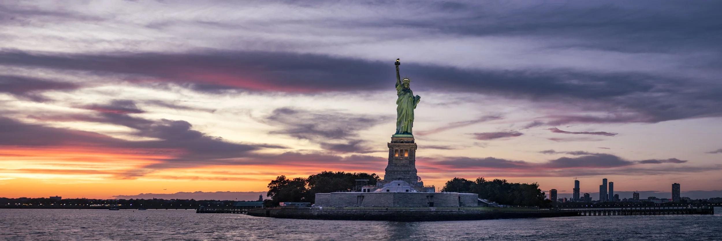 Iconic panorama landscape photograph of the Statue of Liberty at sunset for sale by local artist NYC