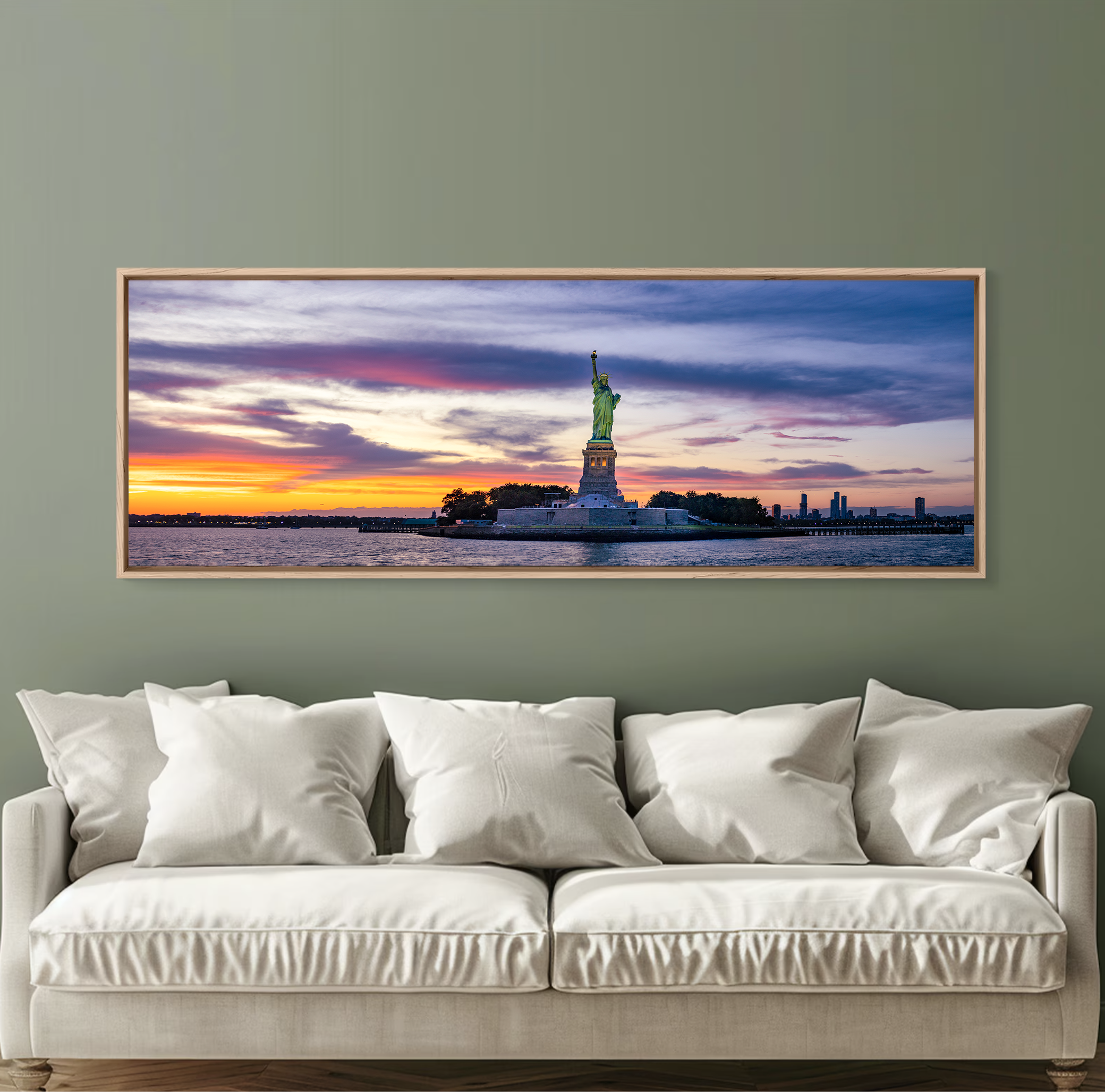 Panoramic fine art photograph of the Statue of Liberty at sunset in New York Harbor, with warm golden and pink tones across the sky and water.