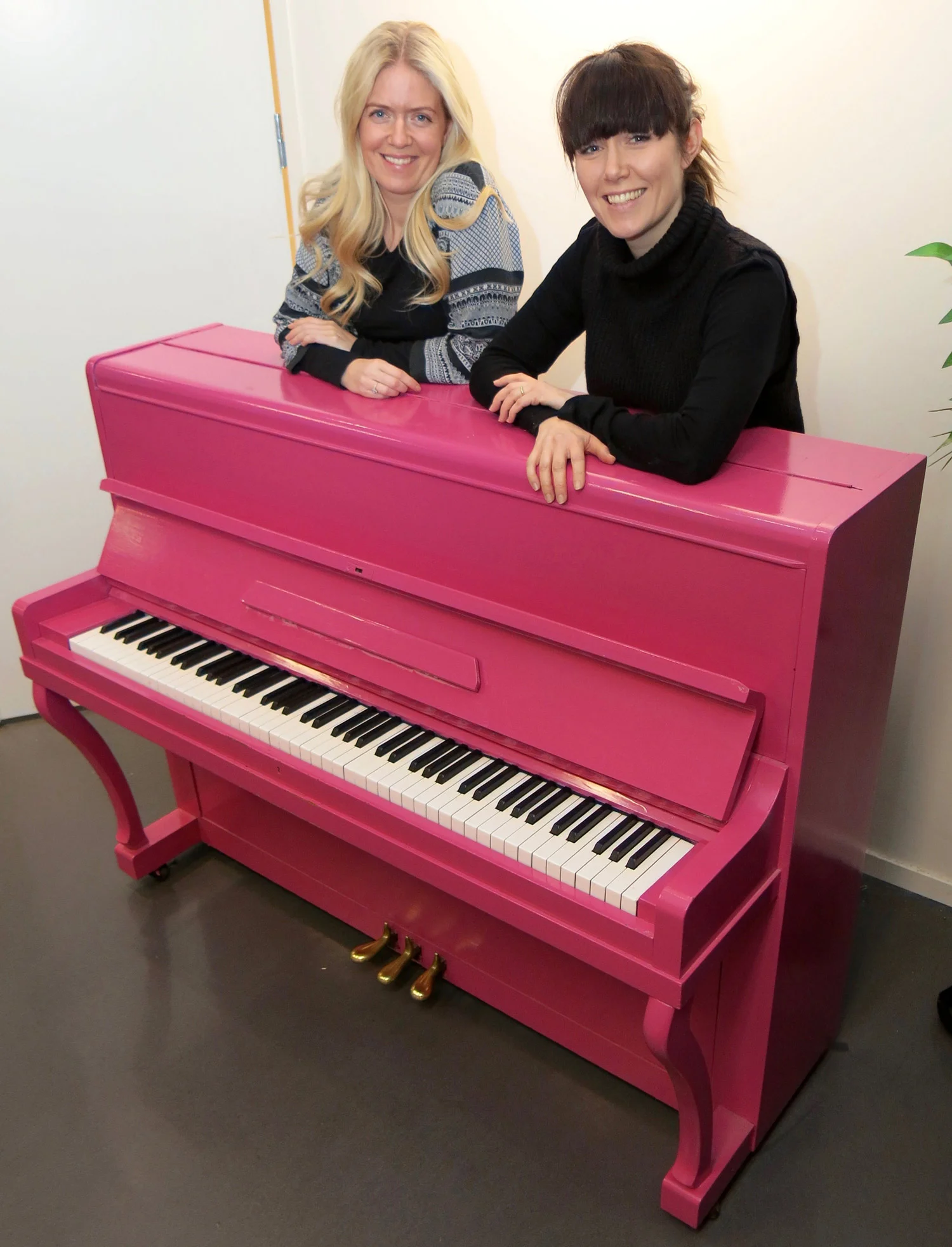 FØDT PÅ NY: Pianoet fant de gratis på Finn.no. Da var det brunt og trist. Nå er det rosa. − Ungene er helt ville etter å spille på det, sier eierne av Showskolen, Guro (t.v) og Marte Helleseter.