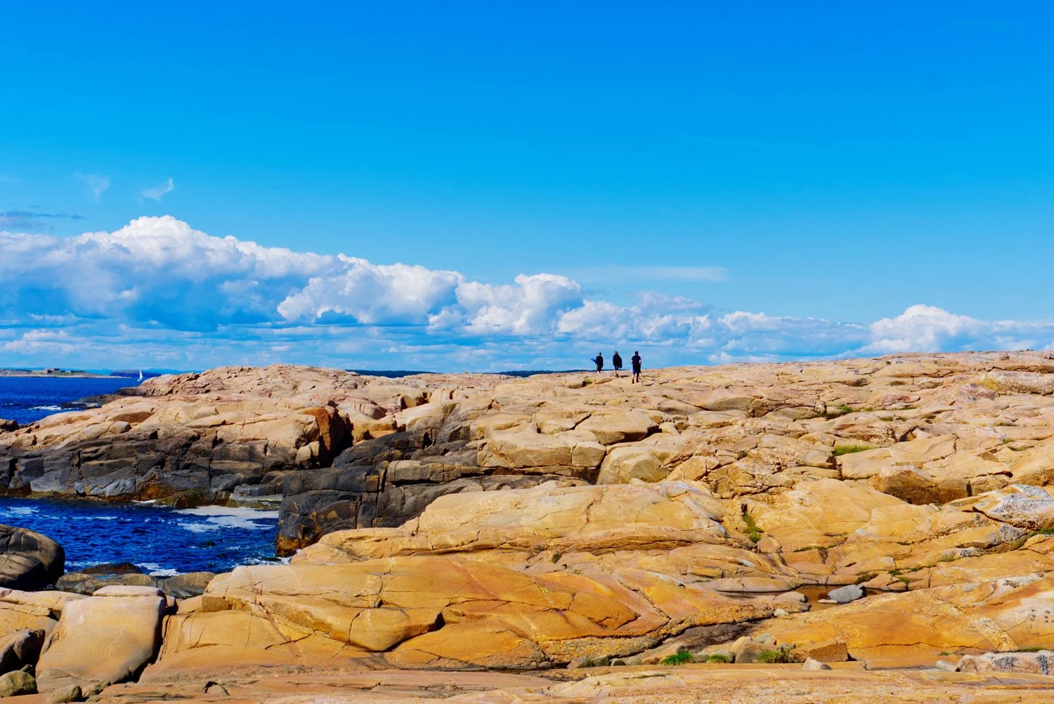 Hvaler-web-three-explorers-hike-along-slabs-rock-along-textured-coast-asmaly-hvaler-norway.jpg