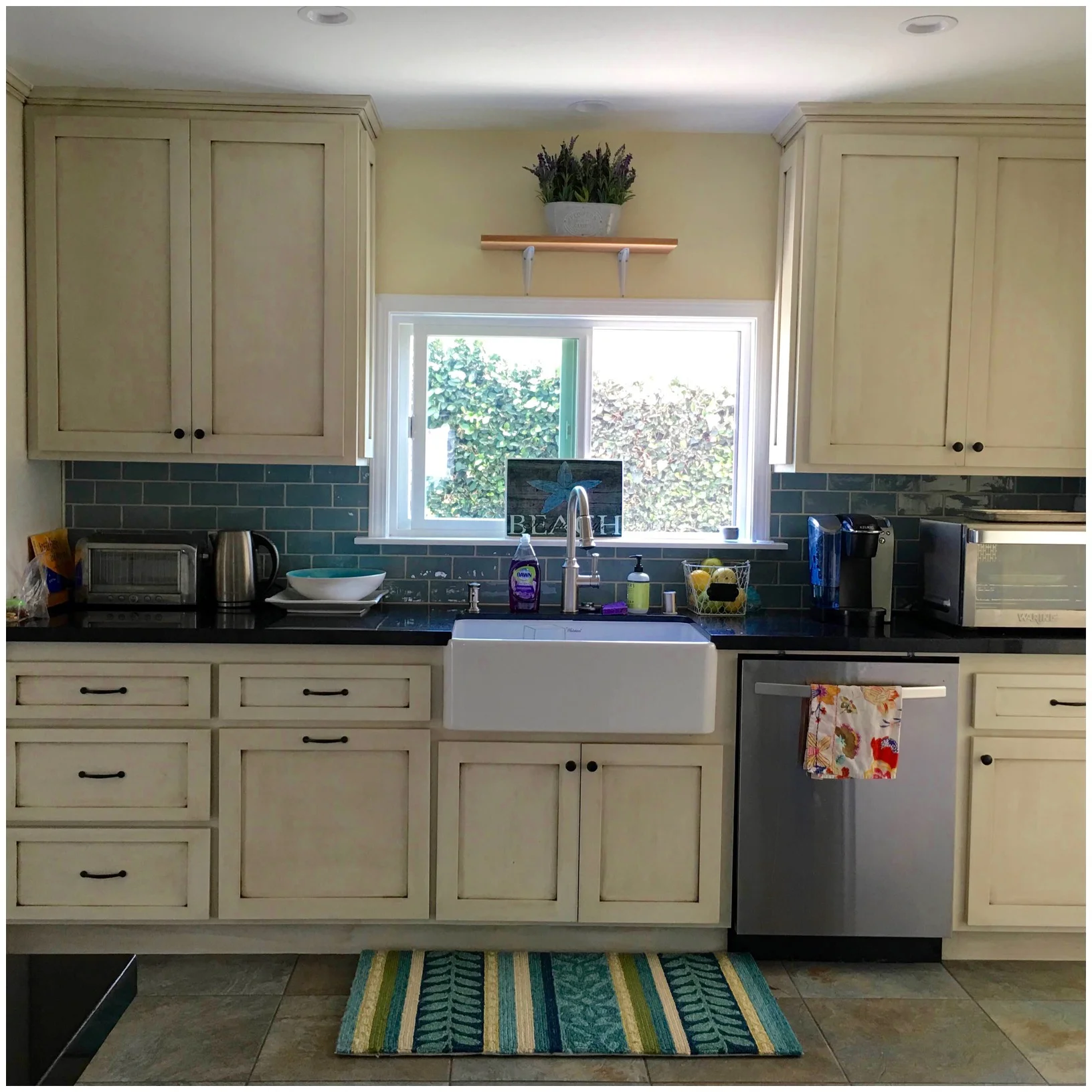 Blue glass subway and stained cream colored cabinets