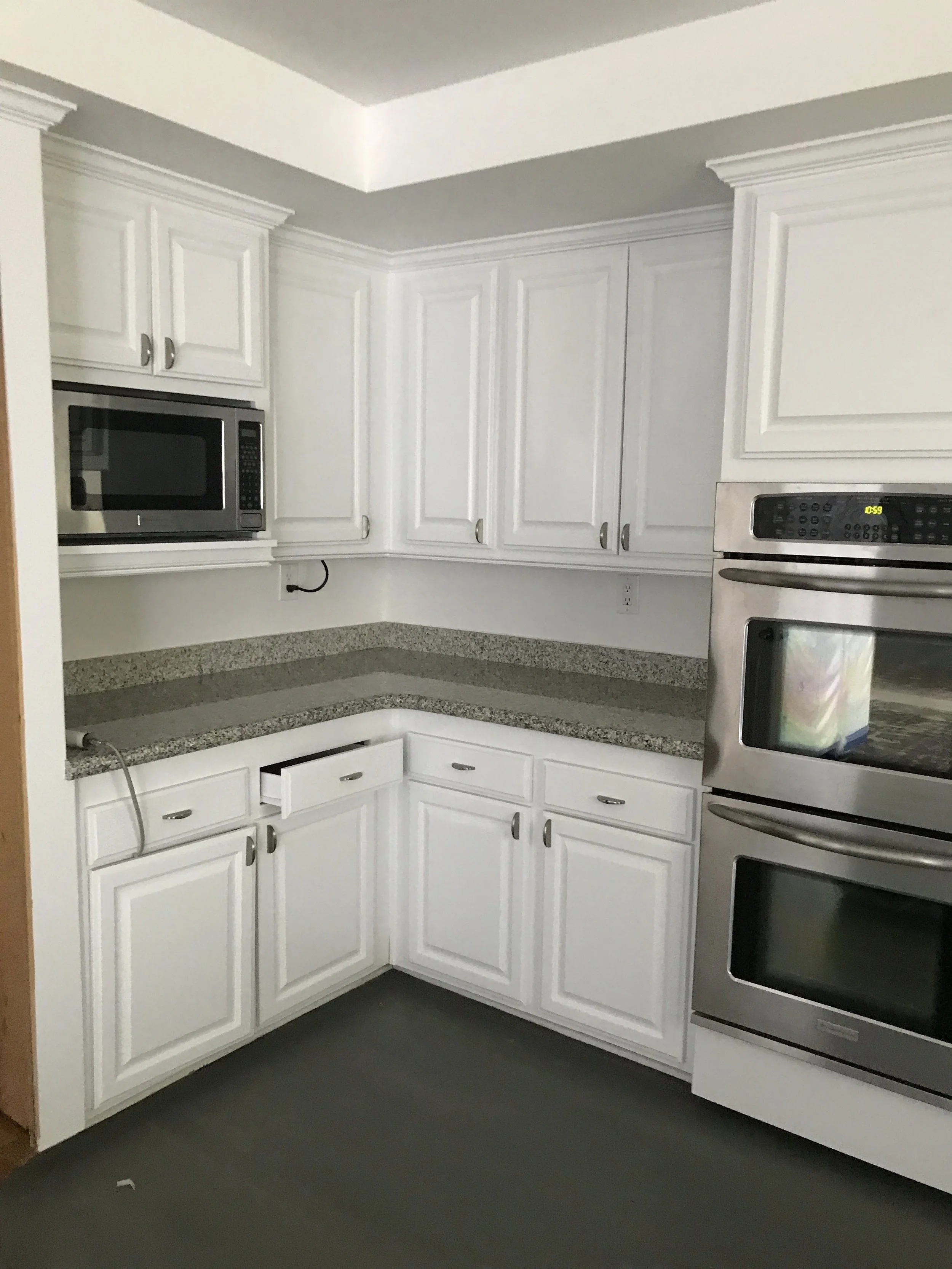 Removing wall to open kitchen into dinning room and creating a center concrete island with waterfall sides.