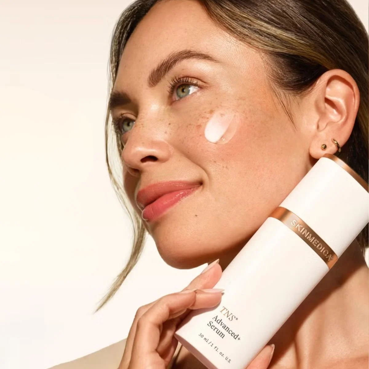 Woman holding bottle of TNS Serum