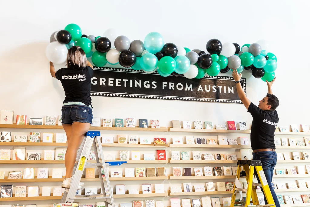 ATX BUBBLES installing a balloon garland at The Paper + Craft Pantry Re-Opening Party.