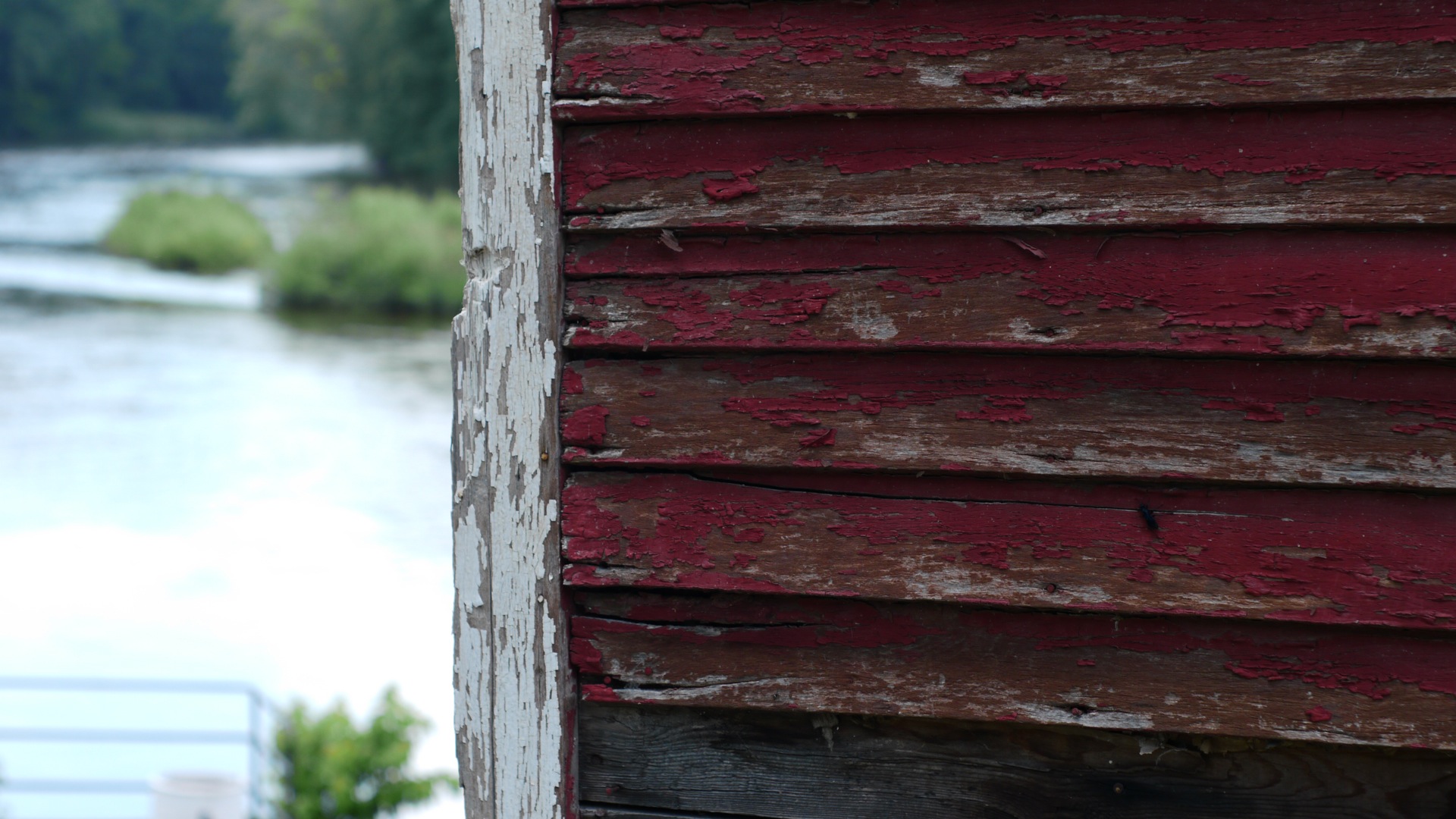 Picture of a weathered red clapboard building wall