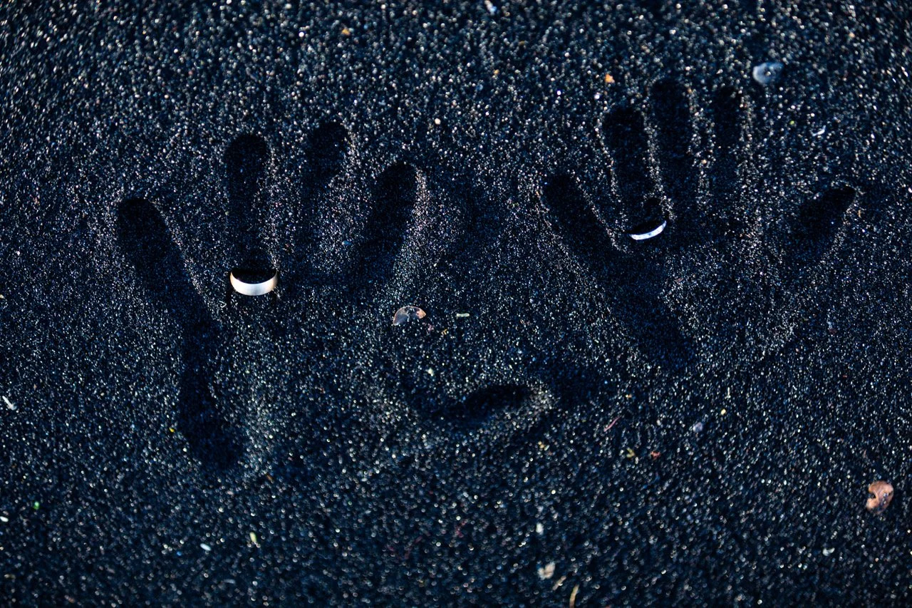 Hands impression on black sand at Wedding ceremony at Punalu'u Black Sand Beach