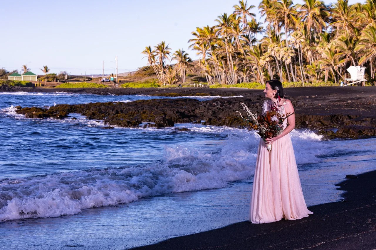 Bride holding bouquet walking on beach at Wedding ceremony at Punalu'u Black Sand Beach