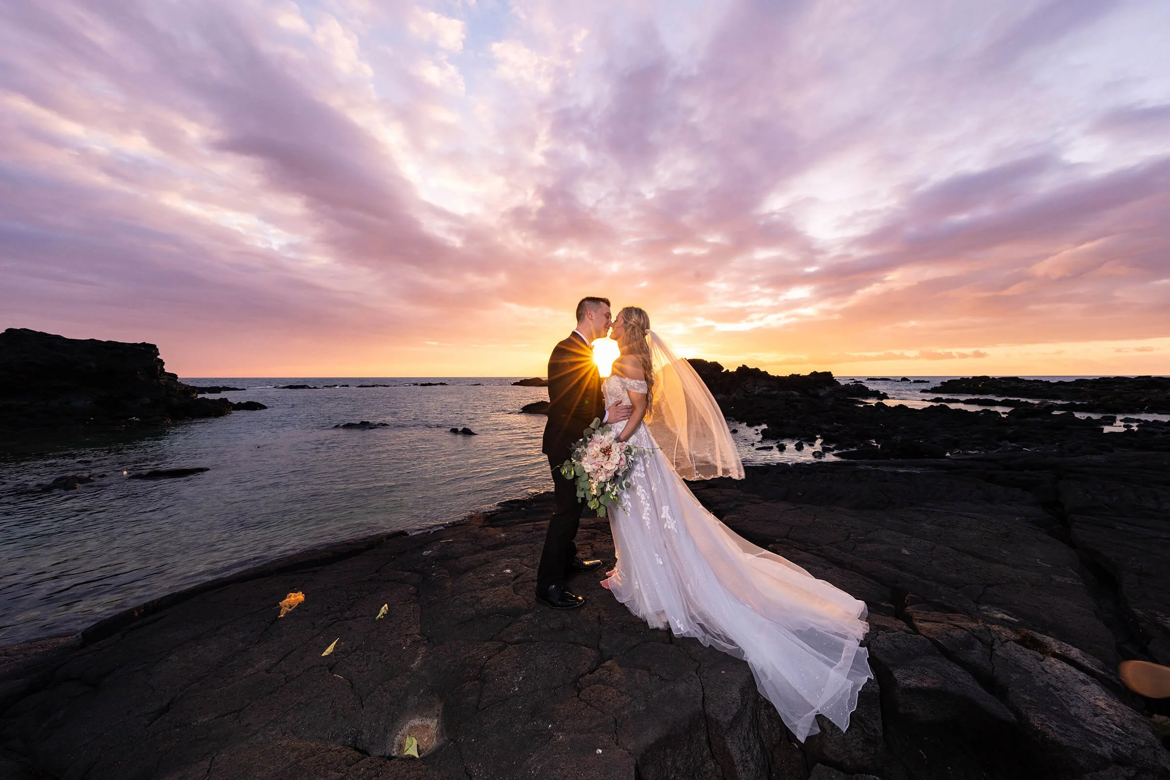 Couple kissing after sunset elopement on black Lava