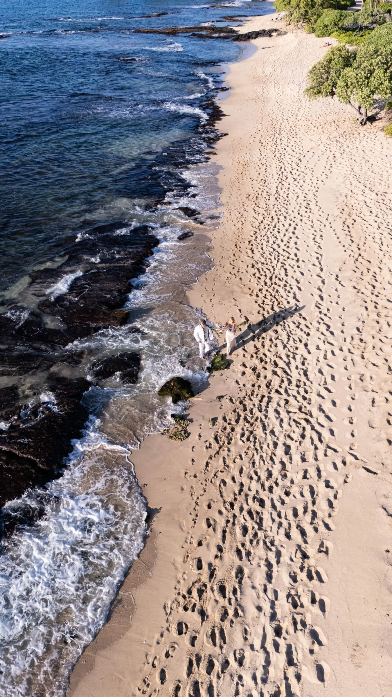 Couple walking at the beach after their Big Island Elopement