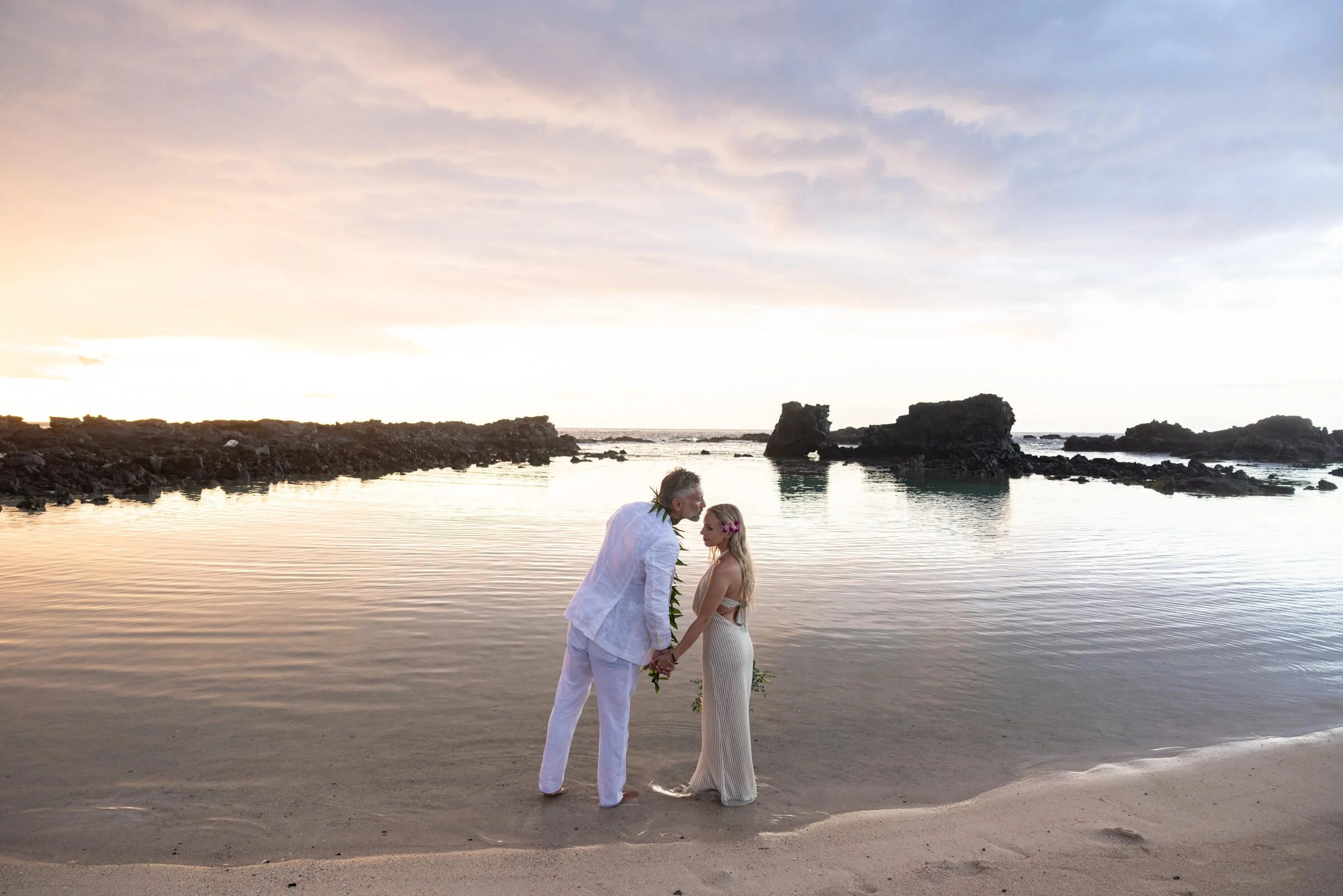 Couple at the beach in Hawaii in wedding attire