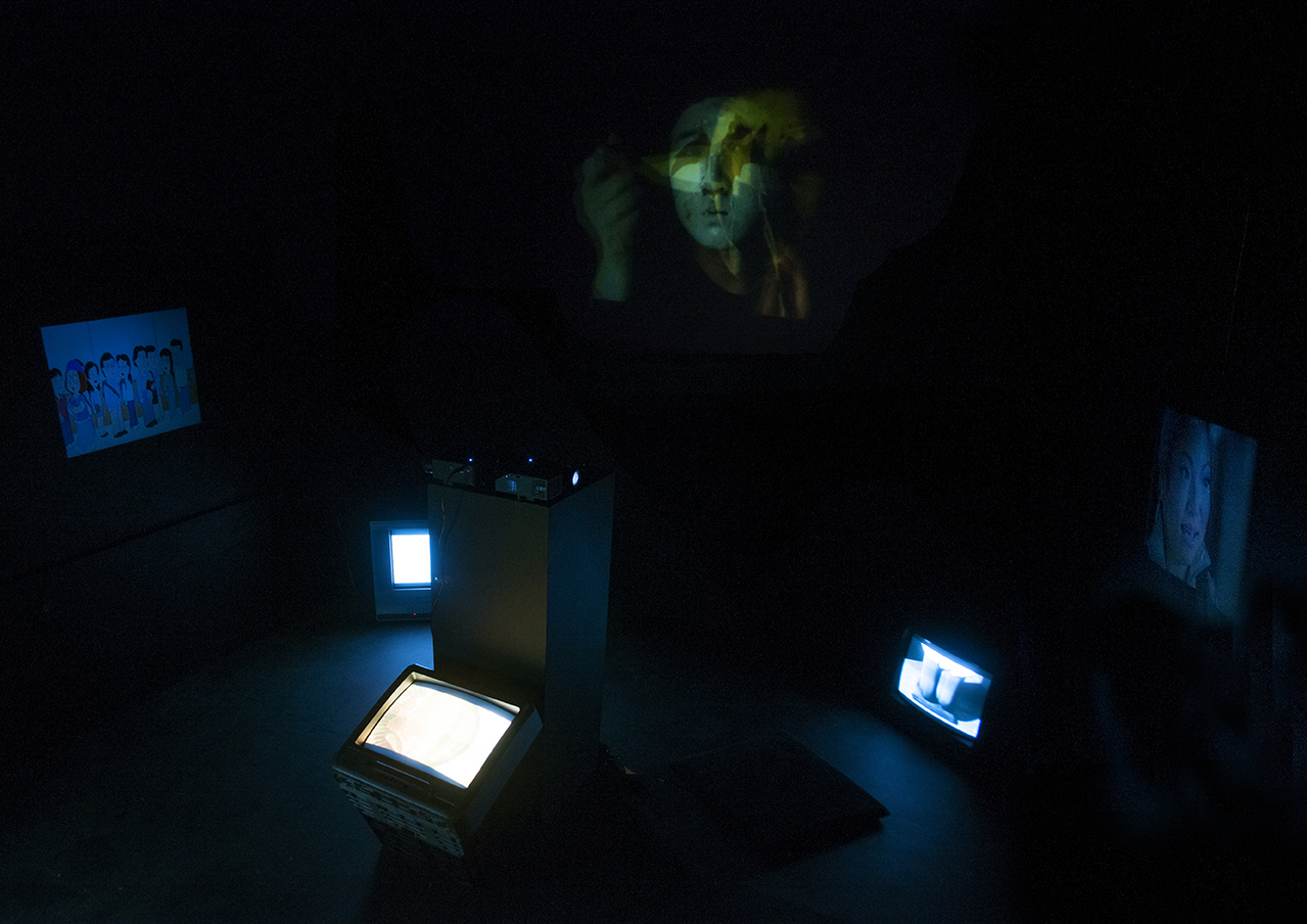 Hyphen (self-portrait) Multimedia installation: projection, sound, television, DVDs in a constructed room 96x125x96 inches. Installation view.
