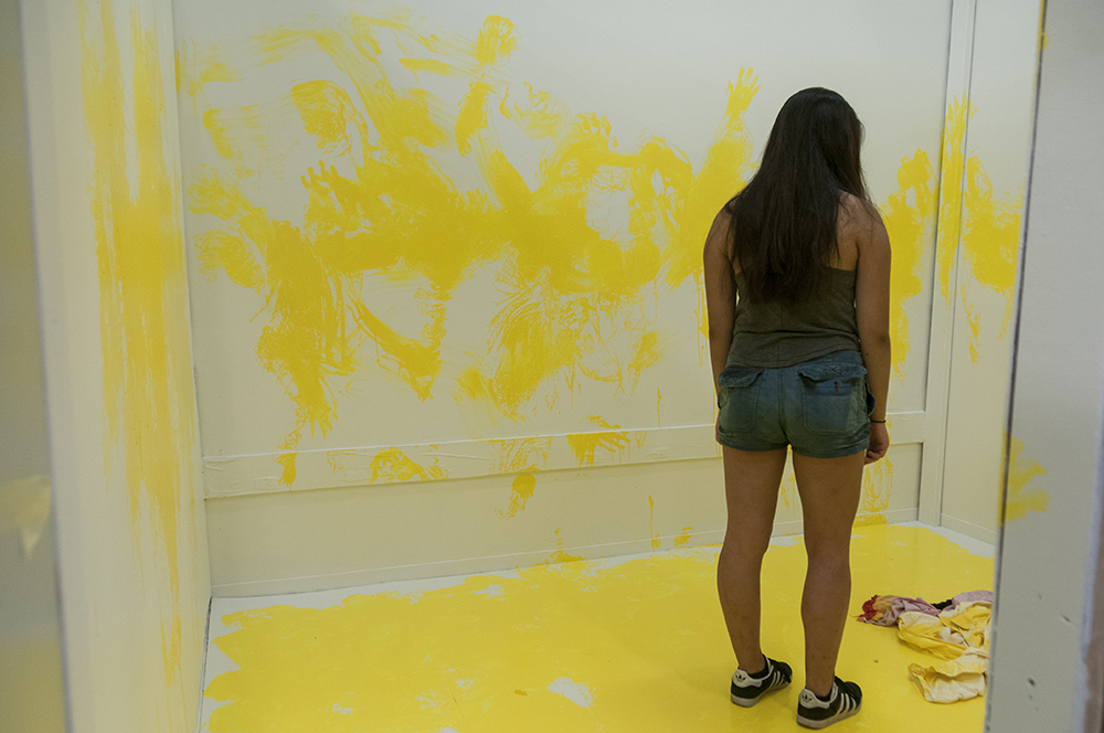 Marking. Multimedia installation: yellow paint, oriental kimono, Coverall, googles, face mask, paint can, paint opener, documented performance, and television sets. 96x125x96 inches. Installation view.