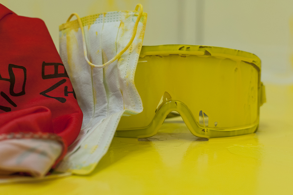 Marking. Multimedia installation: yellow paint, oriental kimono, Coverall, googles, face mask, paint can, paint opener, documented performance, and television sets. 96x125x96 inches. Installation view.
