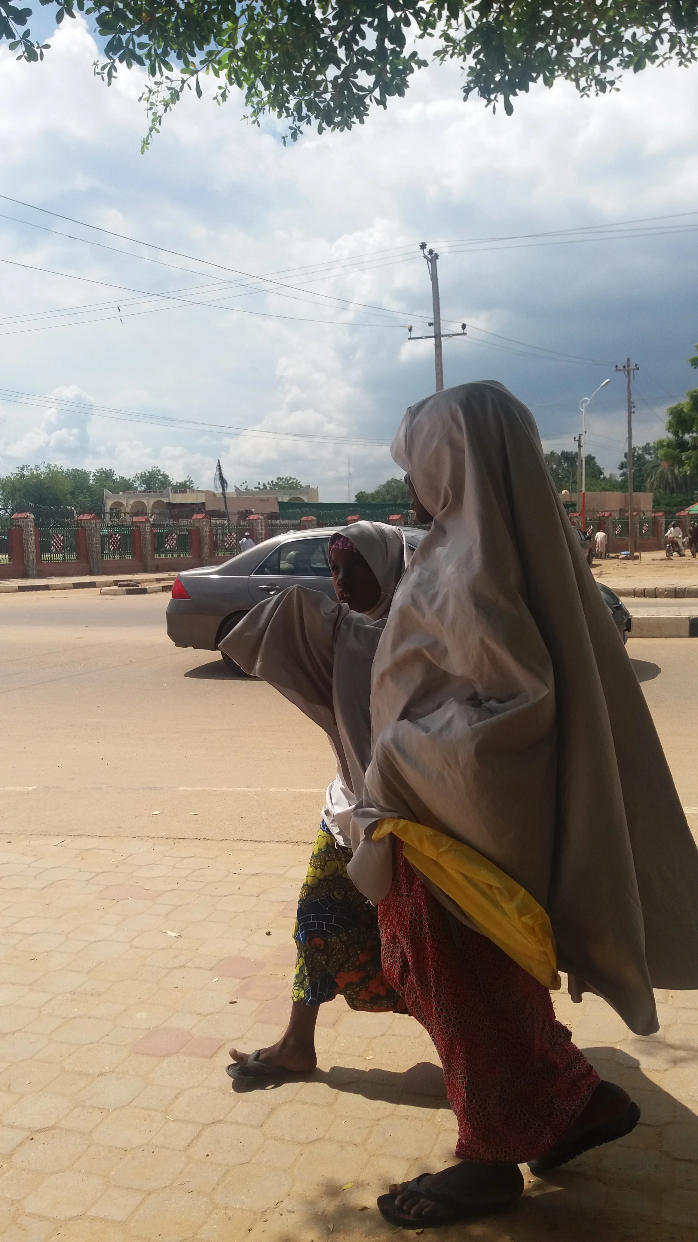 Young Girls Walking, dressed in Grey Hijab © Kano, 2017