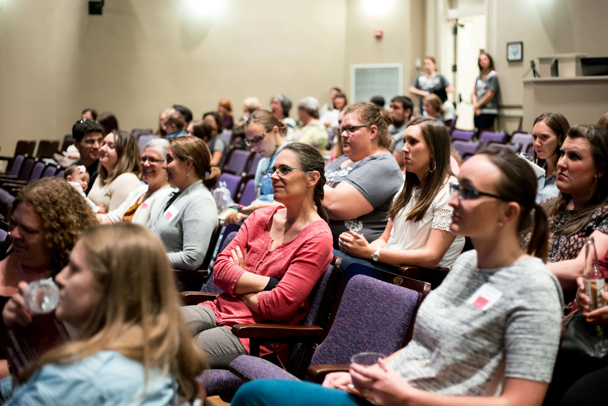 Community partners, Ashley Graham LCSW, Leslie Payne CPM, Erin Baird CNM, Lisa Neumann CNM , Amy Rugh LPC, Katie Page CNM, and more sit among brave men and women while volunteer staff lovingly watch over the crowd. © Christi Stafford Photography