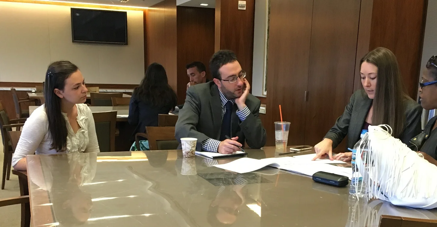 Kate Petrie and attorneys from Gibbons, PC talk with a client seeking help at our monthly Expungement Clinic. 