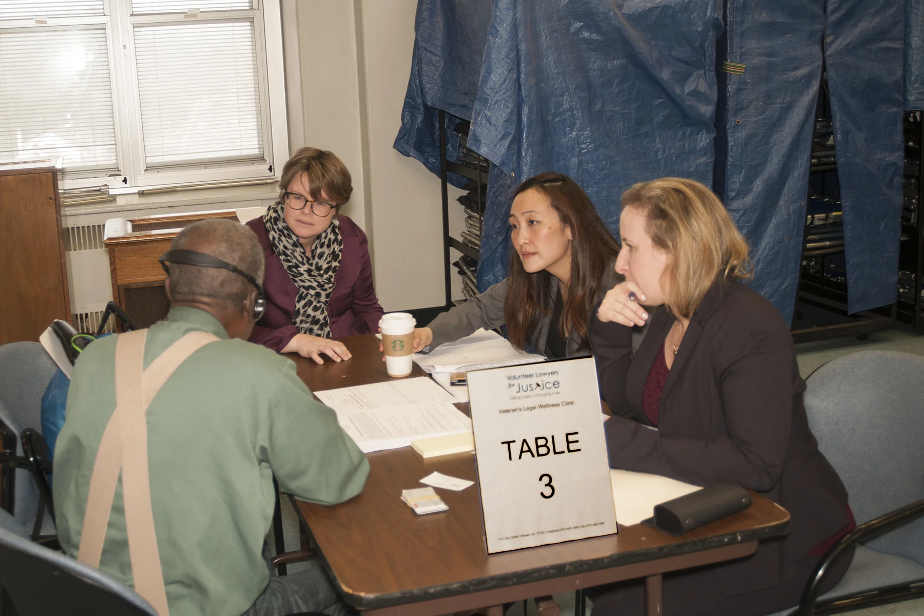 Attorneys from Panasonic and Nukk-Freeman meet with veteran client at February 2017 Wellness Clinic.