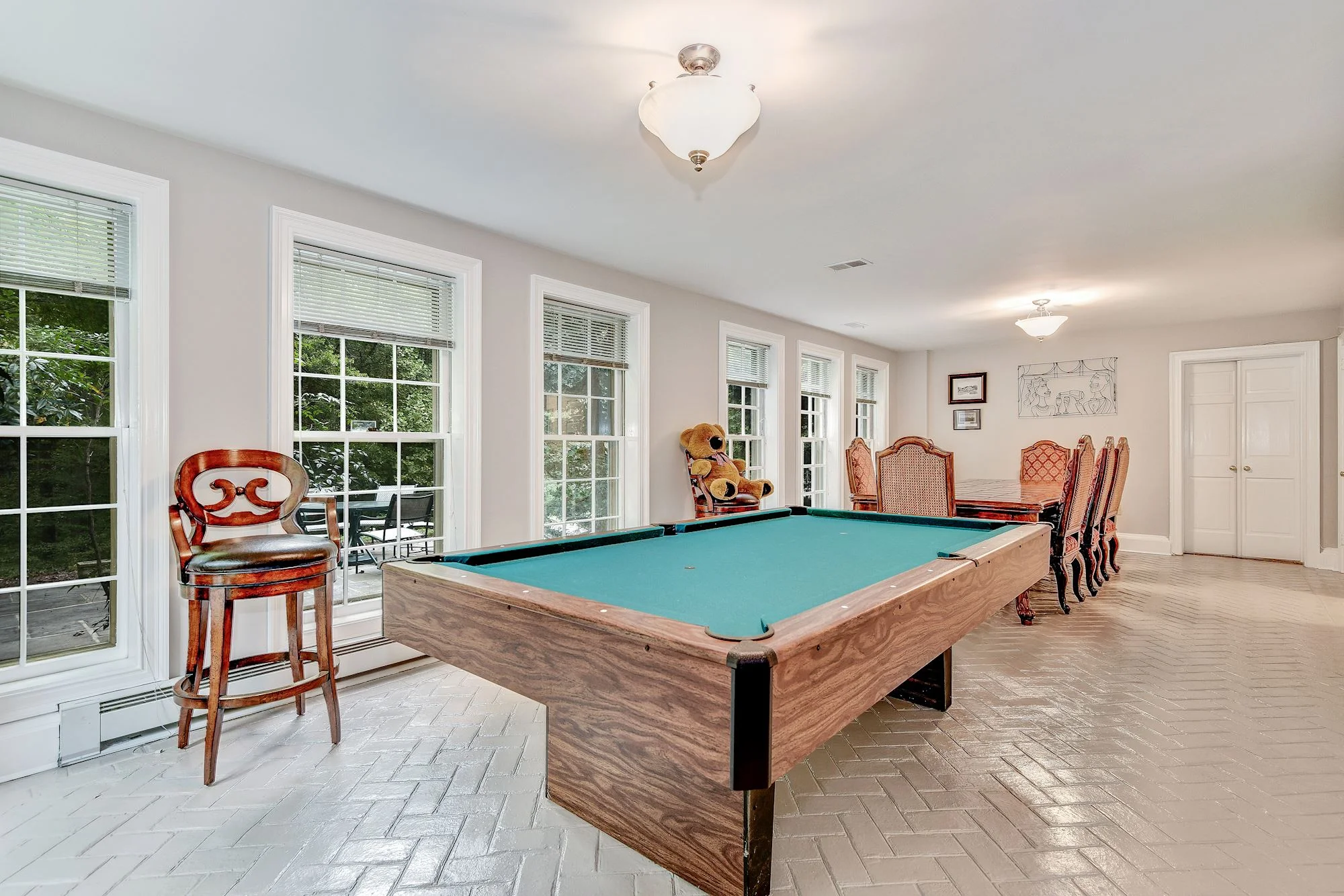 The Recreation Room features herringbone brick floors, a Kitchenette and opens to outdoor entertaining