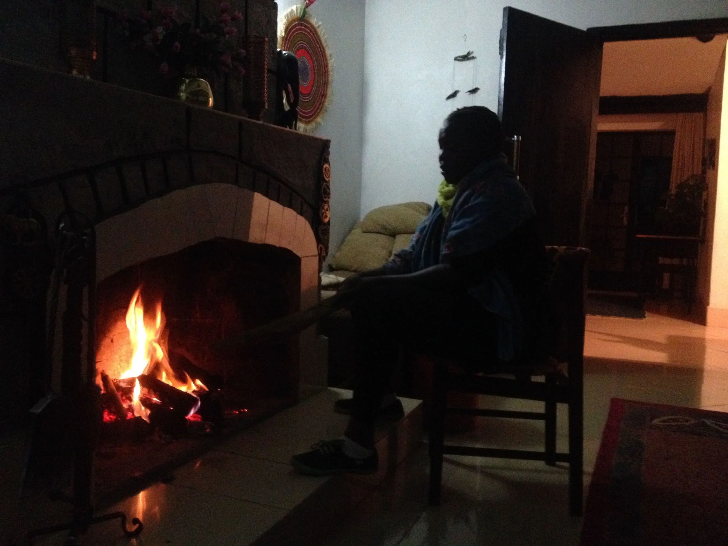 Martha sits in front of the fire at the B&B in Naivasha.