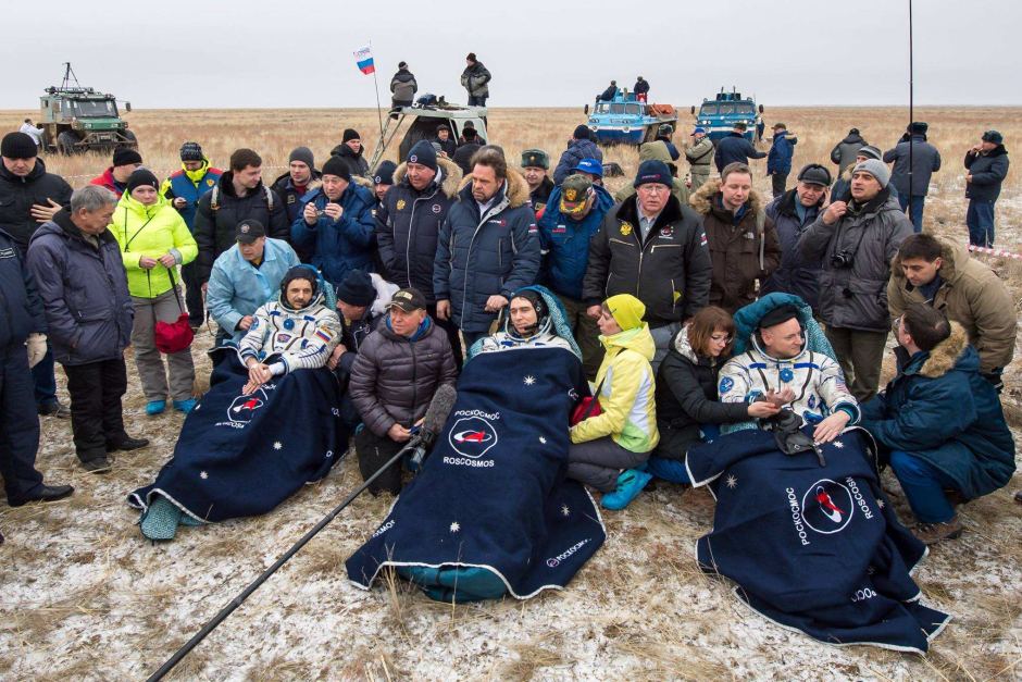 Russian cosmonauts Mikhail Kornienko (left), Sergey Volkov of Roscosmos (center), and Astronaut Scott Kelly rest in chairs outside their Soyuz TMA-18M spacecraft. Photo Credit: NASA/Bill Ingalls