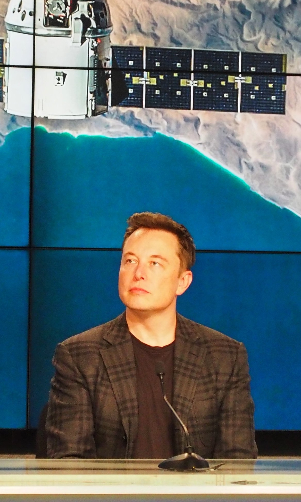 Elon Musk watches a replay of CRS-8's successful landing, at a post-launch press briefing April 8, 2015. Photo credit: theOrbital.space/Josh Dinner