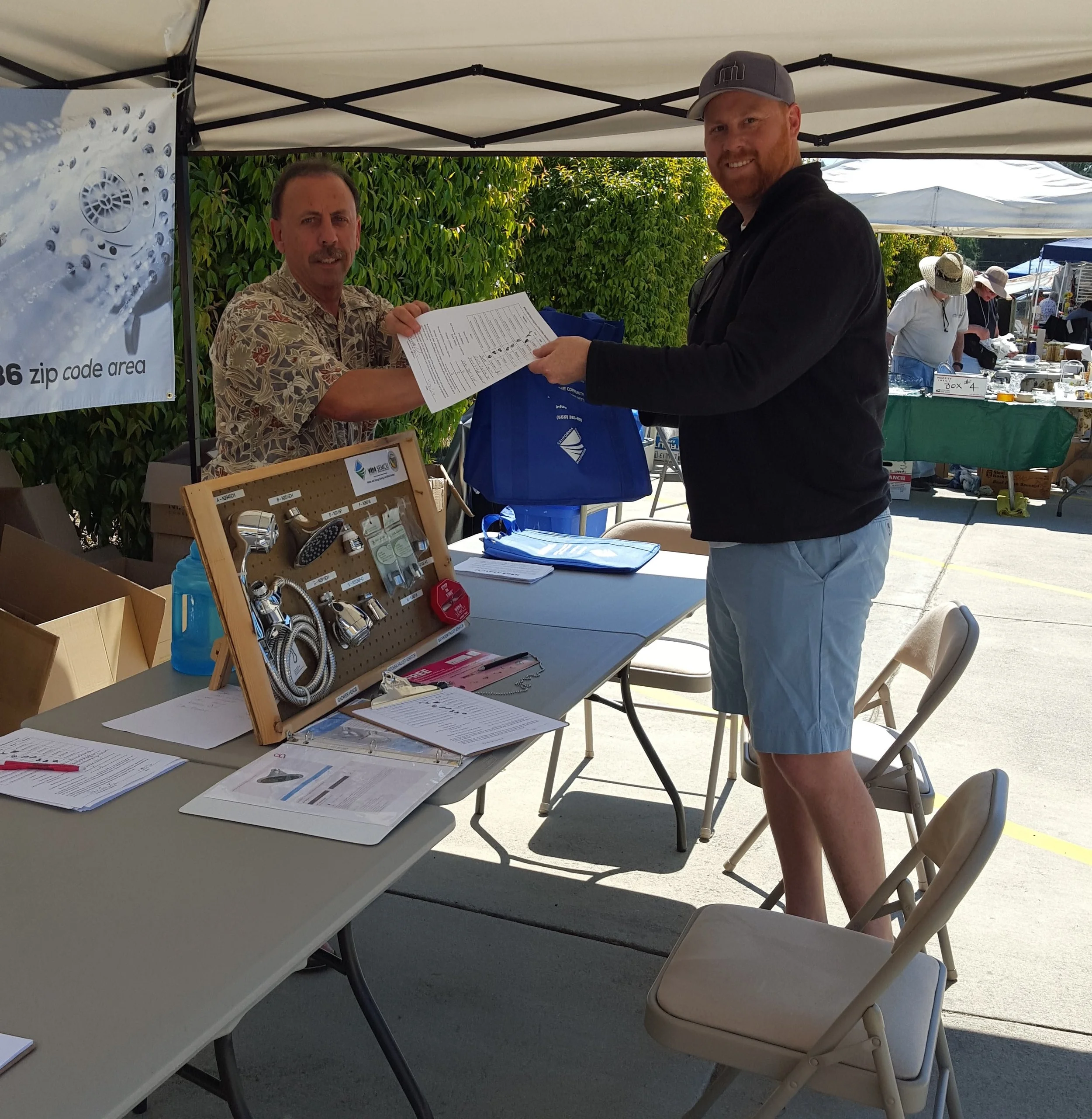 A SEMCU member distributes free water efficiency devices at an outreach event