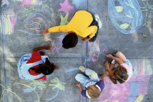 four kids drawing with chalk overhead view.jpg