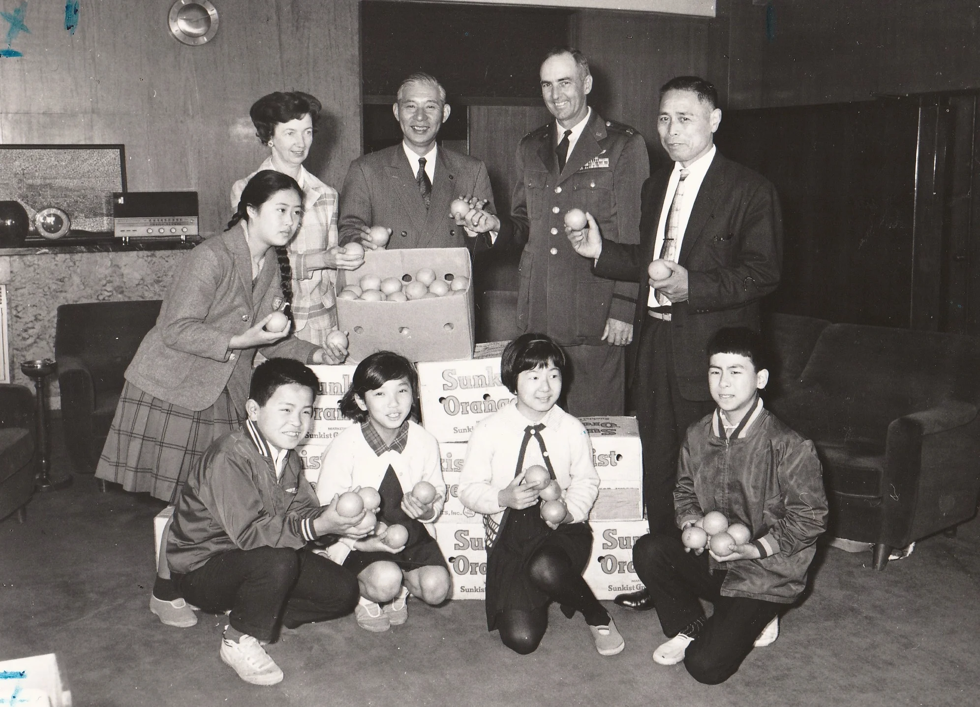 Japanese students and Tachikawa's Mayor Sakurai receiving naval oranges from Mignon and Seymour Schweitzer.