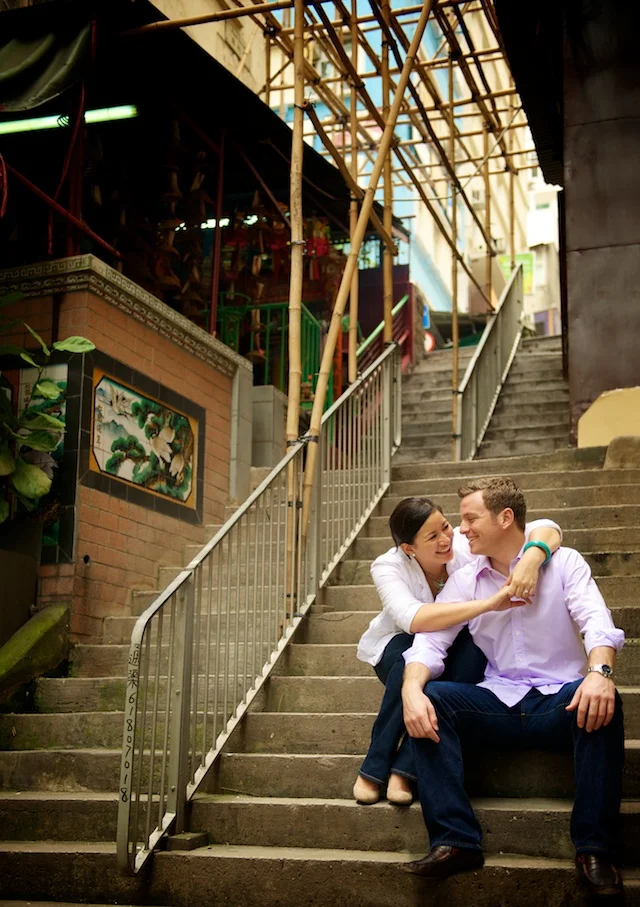 Hong Kong engagement session couple sitting on steps under bamboo scaffolding