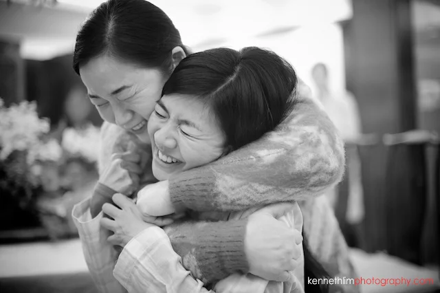 Hong Kong wedding morning preparations bride getting hair done hugging relative