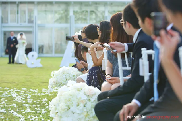Koh Samui wedding YL Residence bride and father walking into aisle guests taking photos
