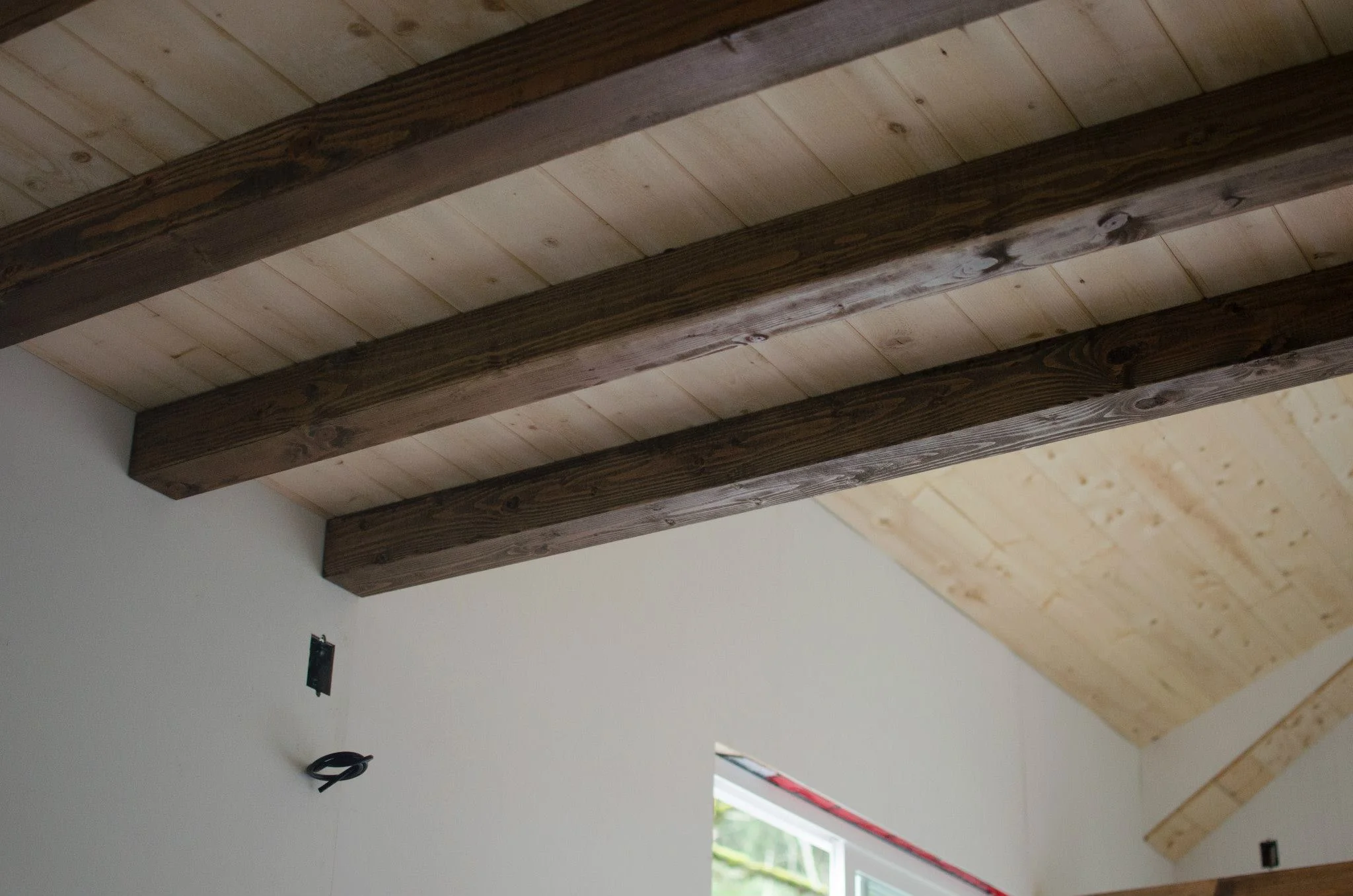 The beams in the living room are custom-milled cedar beams, hand-stained to match the floor.