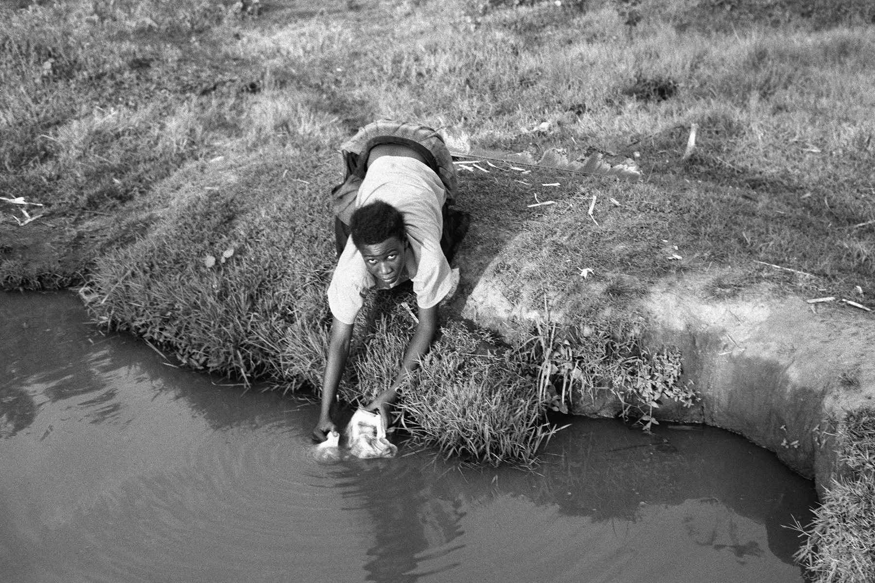Photographer: Anyango Florence. Age: 29 years. Occupation: Teacher at BESO Junior School. "This young woman was stretching hard to collect water from the source. It was risky for her because of the ground height and the water source height. Additionally there was a bush surrounding that was full of snakes!"
