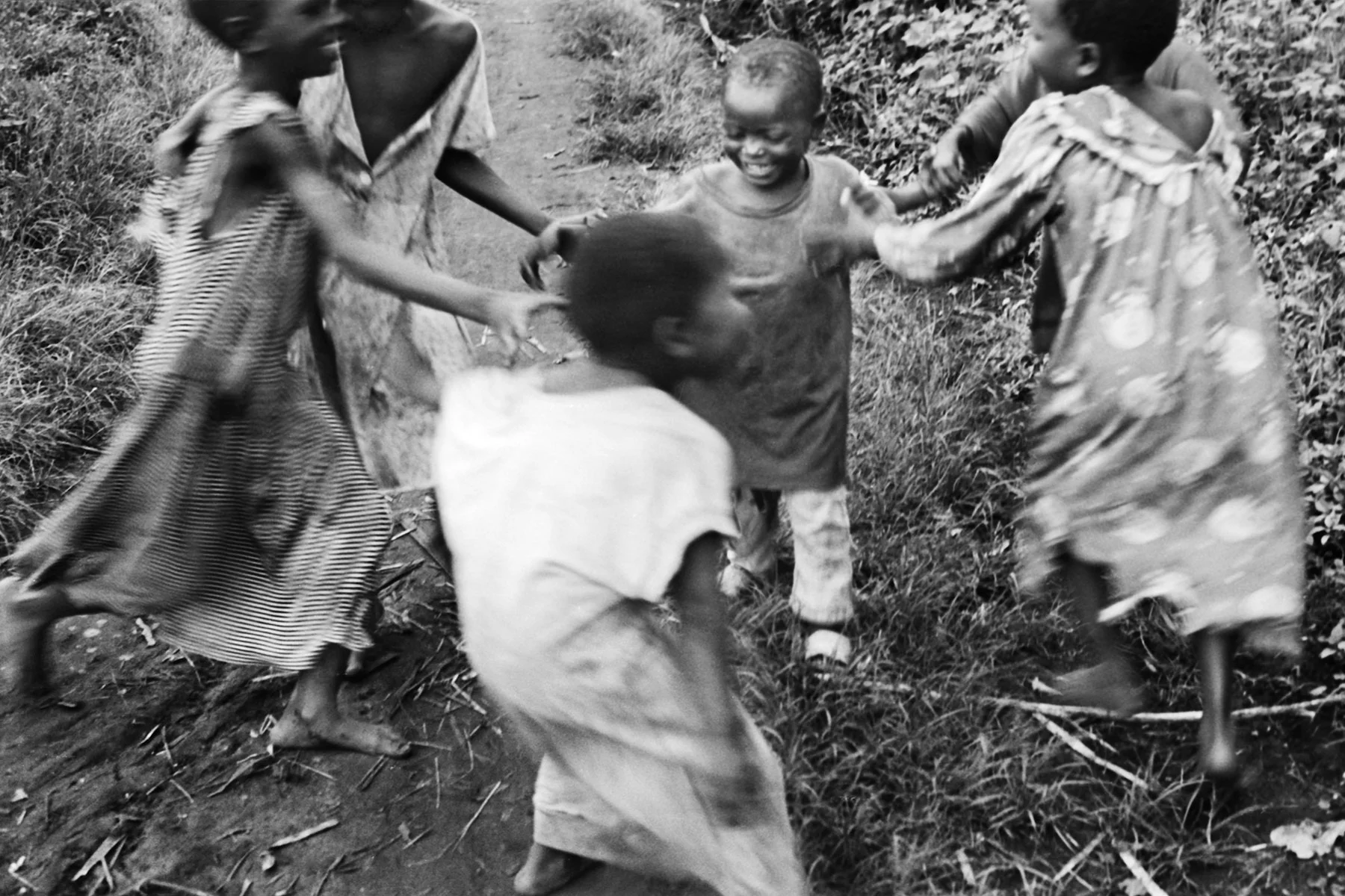 Photographer: Athieno Jane. Age: 42 years. Occupation: Farmer & BESO Junior School Cook. "We want to invest in our children because they are the future. They bring us joy. Here are children are playing along their road to school after a long session of examinations."