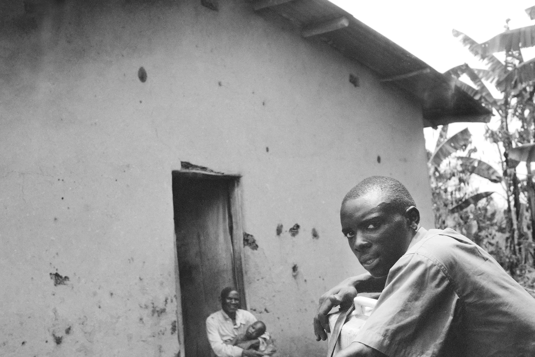 Photographer: Nabunya Rose. Age: 52 years. Occupation: Farmer. "I took this picture because my son had come home to visit us and I was so glad to see him again. He stays near our home and helps with some work, milking my cow."