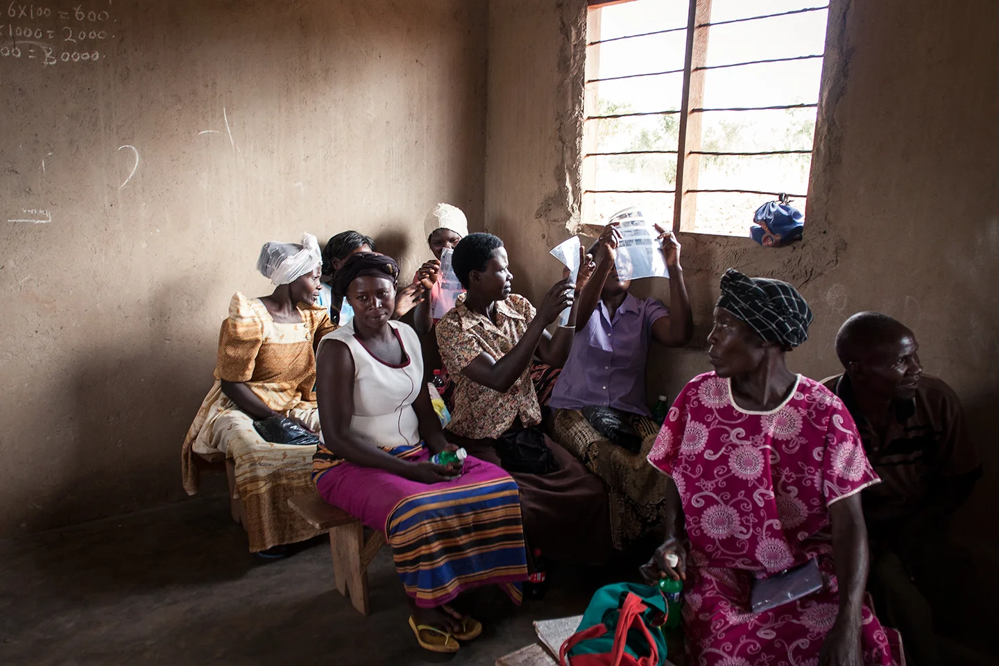 The WPC would gather in the Junior School classrooms designed and managed by their local CBO (community based organization) BESO Foundation. Here the group is looking at their negatives, which they just hand developed for their first time. The magic of film nestles in this important moment. 