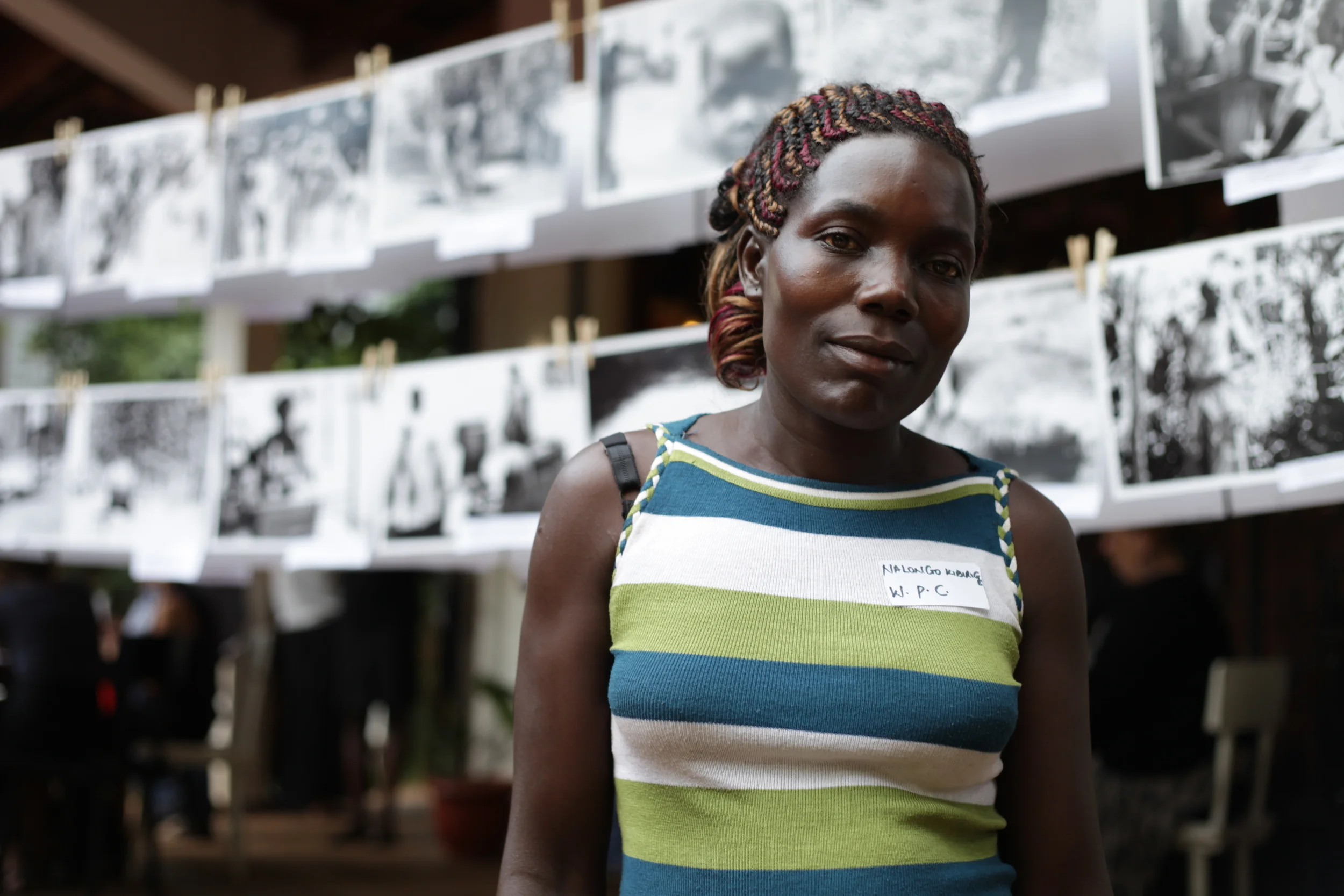  WPC member Kibirigie Nalongo in front of the WPC's photographic works presented at the&nbsp; Picturing Wanteete &nbsp;Kampala Exhibition in May of 2014. 