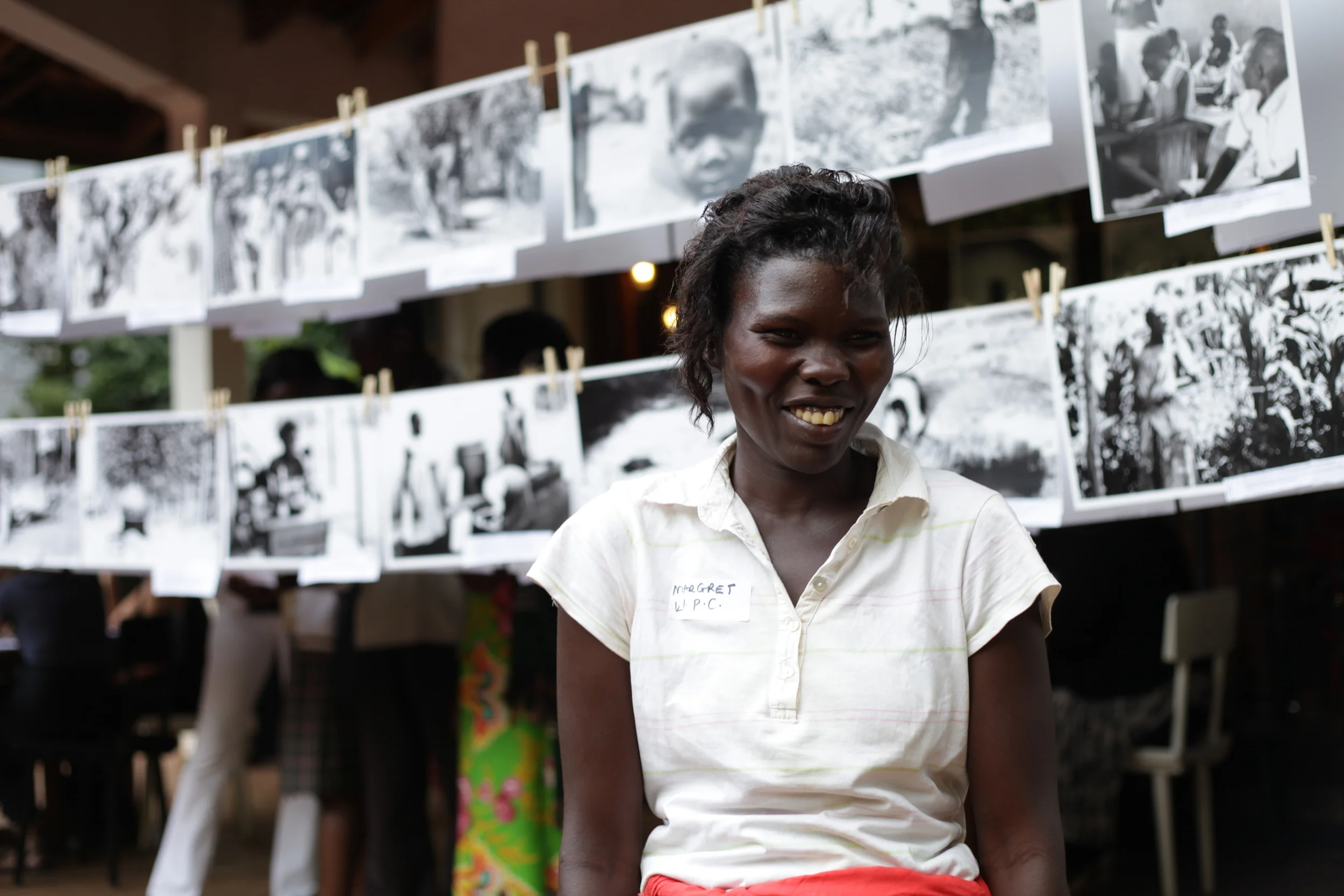  WPC member Achieng Margaret&nbsp;in front of the WPC's photographic works presented at the&nbsp; Picturing Wanteete &nbsp;Kampala Exhibition in May of 2014. 