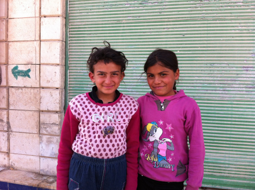  Little girls from Homs standing outside of their makeshift "apartment". 